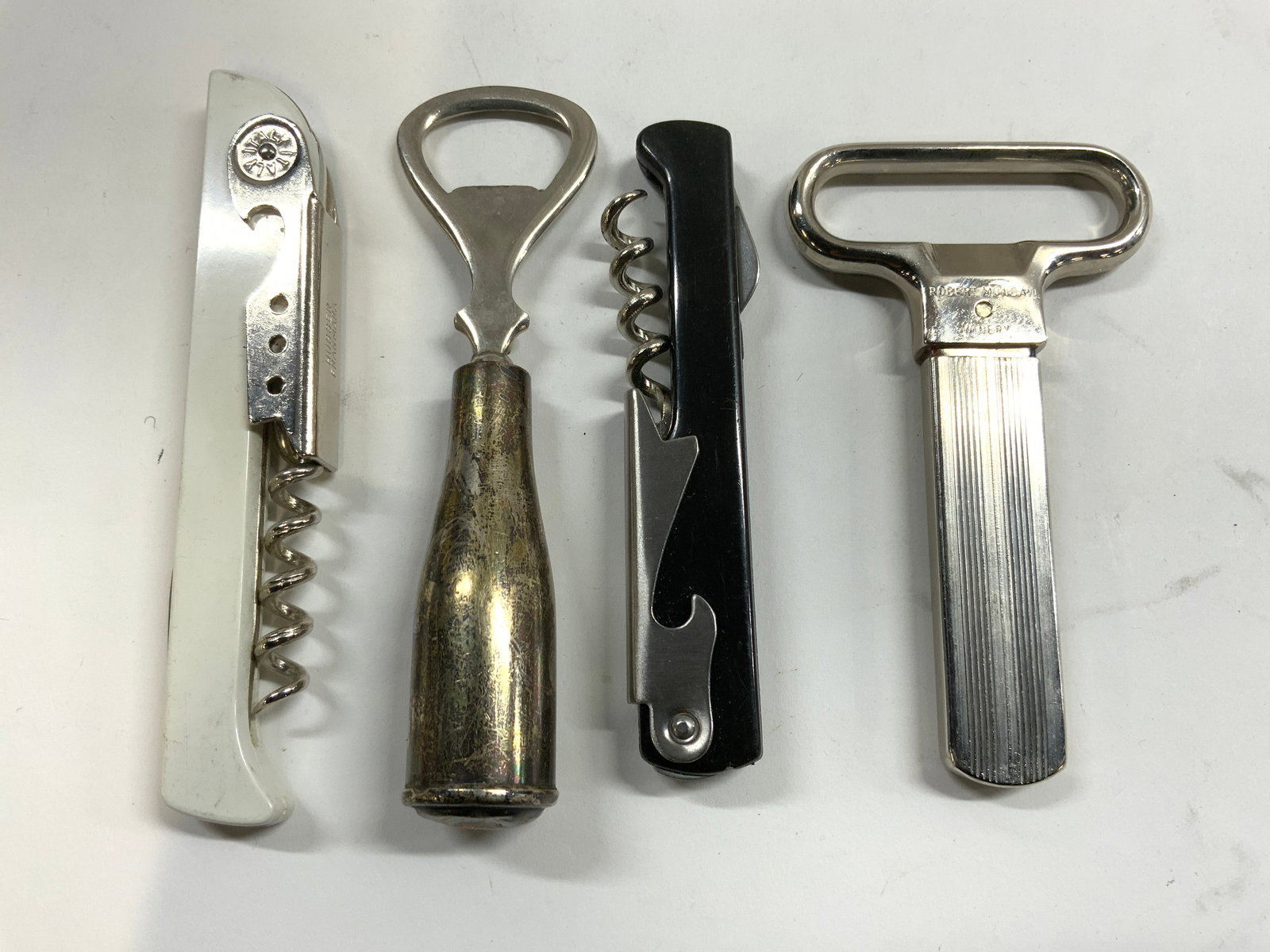 Lot 4 Sterling Silver Handle Bottle Opener & More: Handle of bottle opener is inscribed STERLING. Lot includes 1 sterling handle bottle opener, 1 metal bottle opener inscribed ROBERT MONDAVI WINERY, 1 wine corkscrew trademarked SILVERADO HILL CELLARS