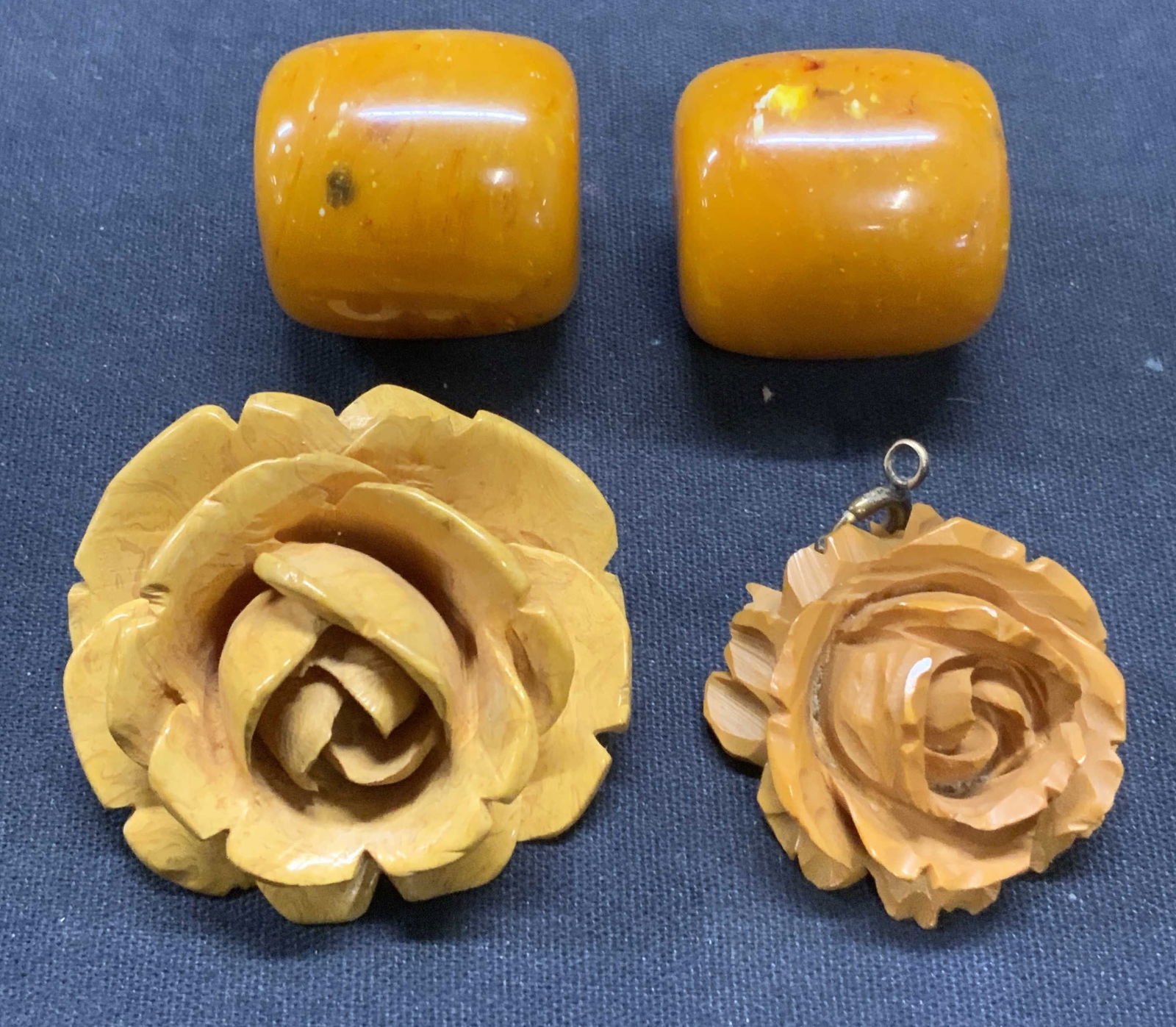 Lot 4 Flower Pendants, Amber Tn Beads: Lot of 4 jewelry pieces. 2 amber tone lucite beads. Measure approx. 1 x 1 inches each. 2 amber tone carved lucite flower pendants. Larger piece measures approx. 1.75 inches wide. All pieces have some