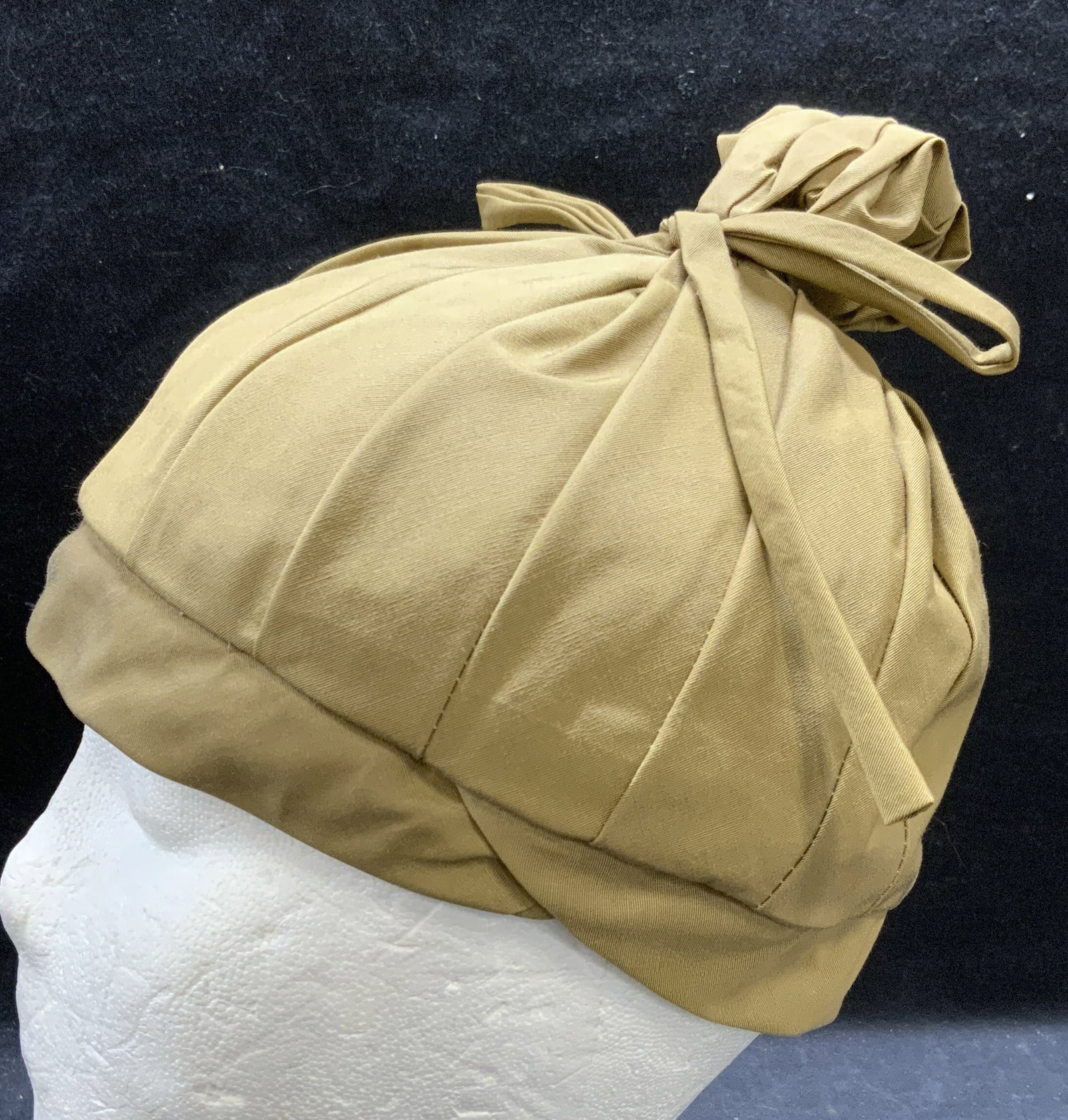 Vintage Tan Pleated Knot Hat: Vintage tan pleated hat with knot and bow decoration. Measures approx. 6 inches wide. Material feels synthetic. Some wear to material consistent with exposure. Includes box. Ladies hat, ladies vintage