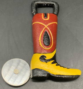 1999 ACCOUTREMENTS Cowboy Boot Bottle Opener: Metal, possibly iron, cowboy boot form bottle opener with articulated silver tone metal spur. Black, yellow, and red hues. Reverse marked 1999 ACCOUTREMENTS. Measures approx. 5L x 4W in. Wear consiste