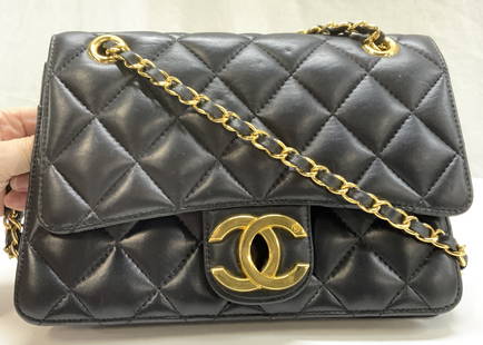 CHANEL STYLE Quilted Leather Shoulder Bag: A classic quilted leather fold over flap Chanel style shoulder bag. Gold tone interlocking CC on flap and woven leather through gold tone chain straps. 10 in drop. Extends to single strap , 17.5 in. D