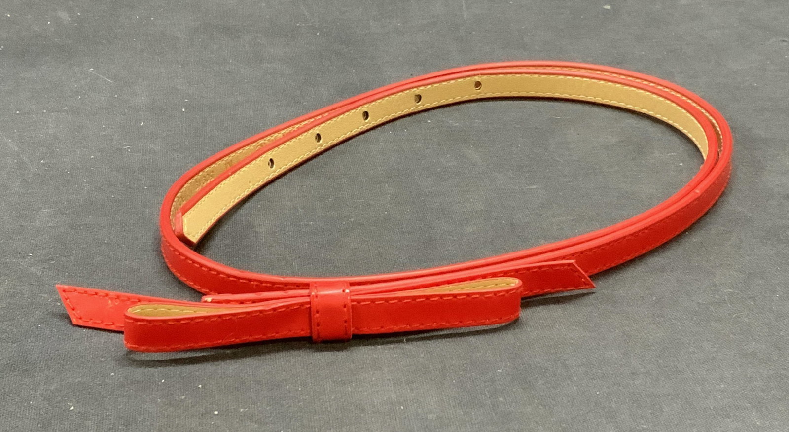 Red Leather Bow Belt: Red leather belt with bow decoration. Measures approx. 39.25 inches long. Some wear to leather consistent with exposure. Ladies belt, ladies bow belt, ladies leather belt, ladies red belt, ladies acce