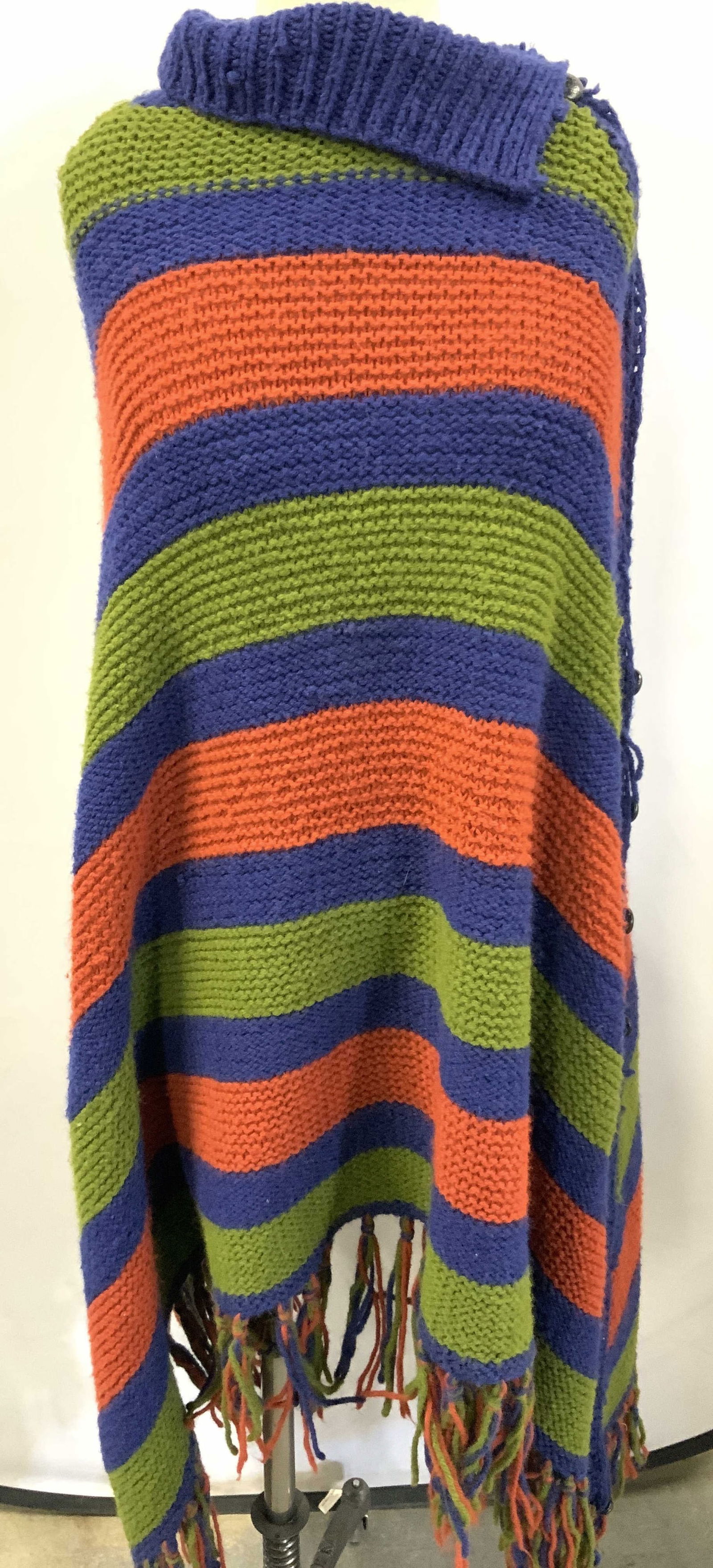 Crocheted Striped Poncho: Hand crafted crocheted striped poncho in tones of blue, green and orange with buttons affixing two sides together. Approx 52 inches long Moderate wearing to crocheting due to age and use. Crocheted po