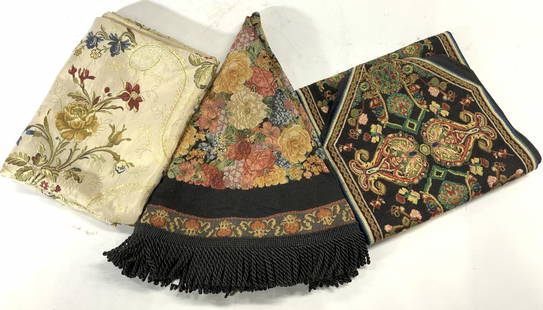 Lot 3 Table Runners & Tablecloths: Lot includes 1 table runner and 2 table cloths. Table runner has floral, leaf, scroll & geometric detail. One table cover is circular shaped & black with multi toned floral and leaf detail with fringe