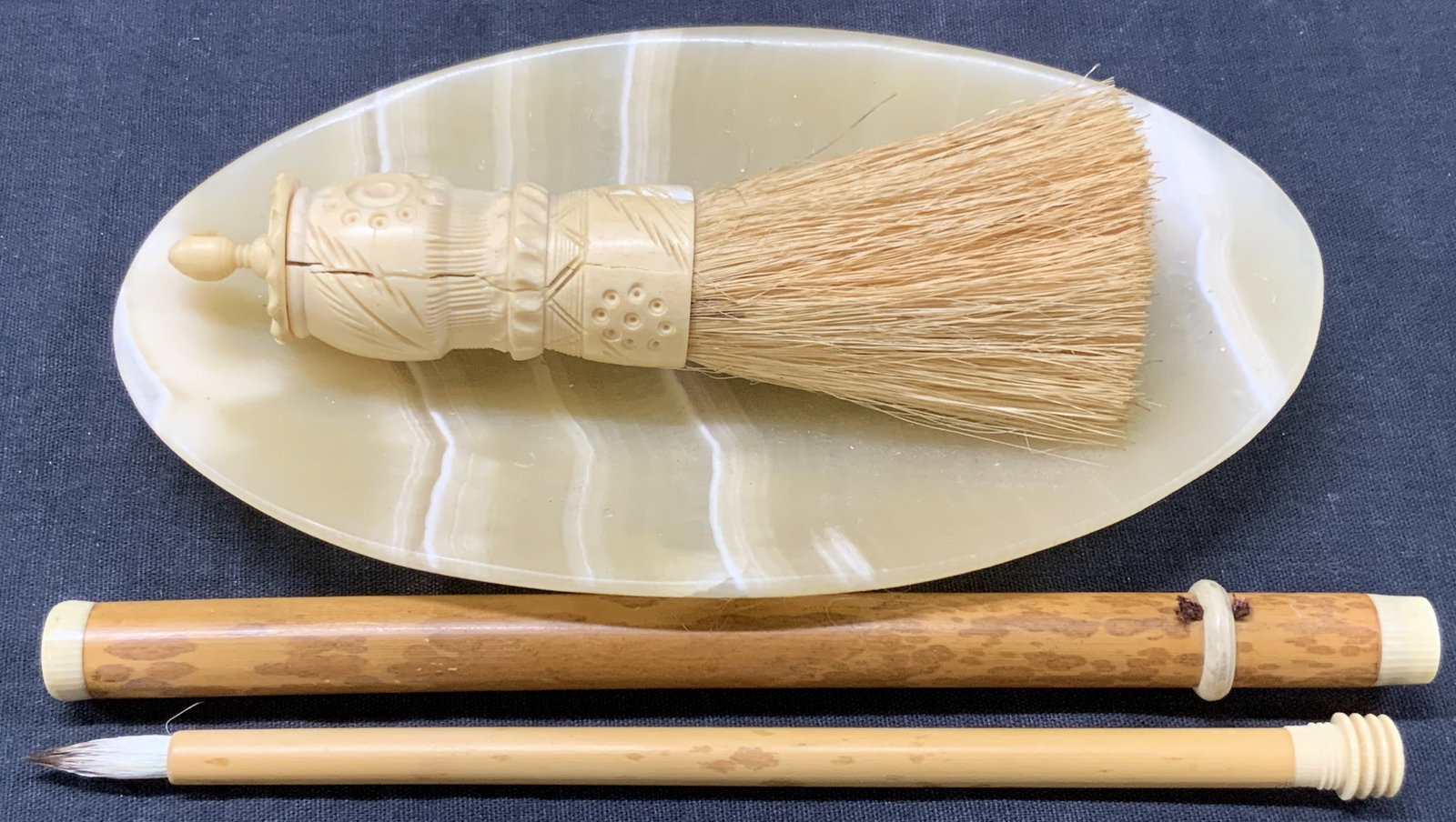 Lot 3 Carved Bone & Stone Accessories: Lot of 3 assorted carved bone and stone accessories. 1 shaving brush with a carved bone handle, at 5.5 inches long. 1 stone trinket dish at 7 inch diameter and 1 bamboo and made calligraphy brush at 7