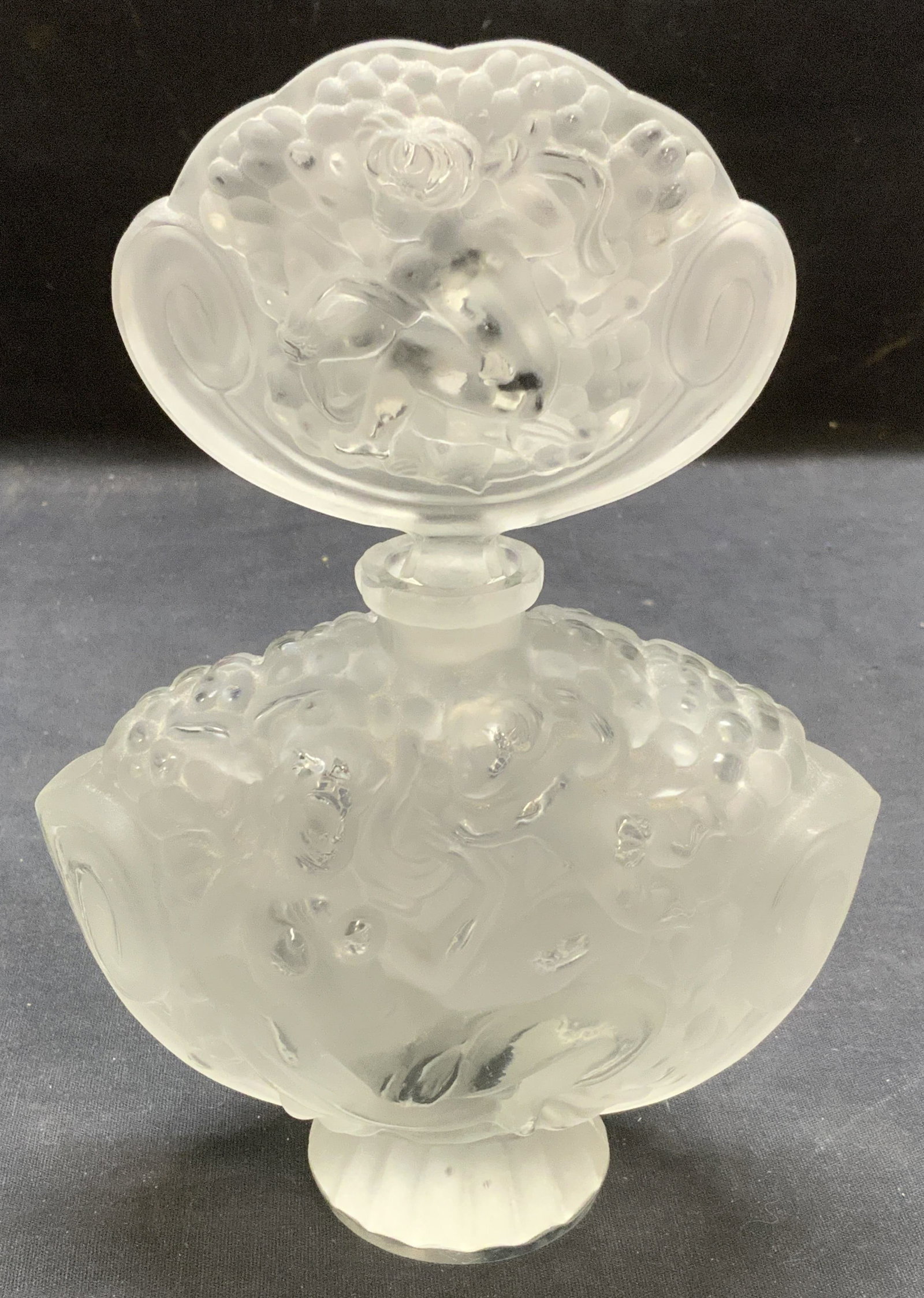 Vintage Art Glass Nude Figural Perfume Bottle: Vintage art glass perfume bottle with nude and cherub figural motif. Embossed raised surface. Style of Rene Lalique. No visible signatures. Thick walled glass, piece has weight. Bottle measures approx