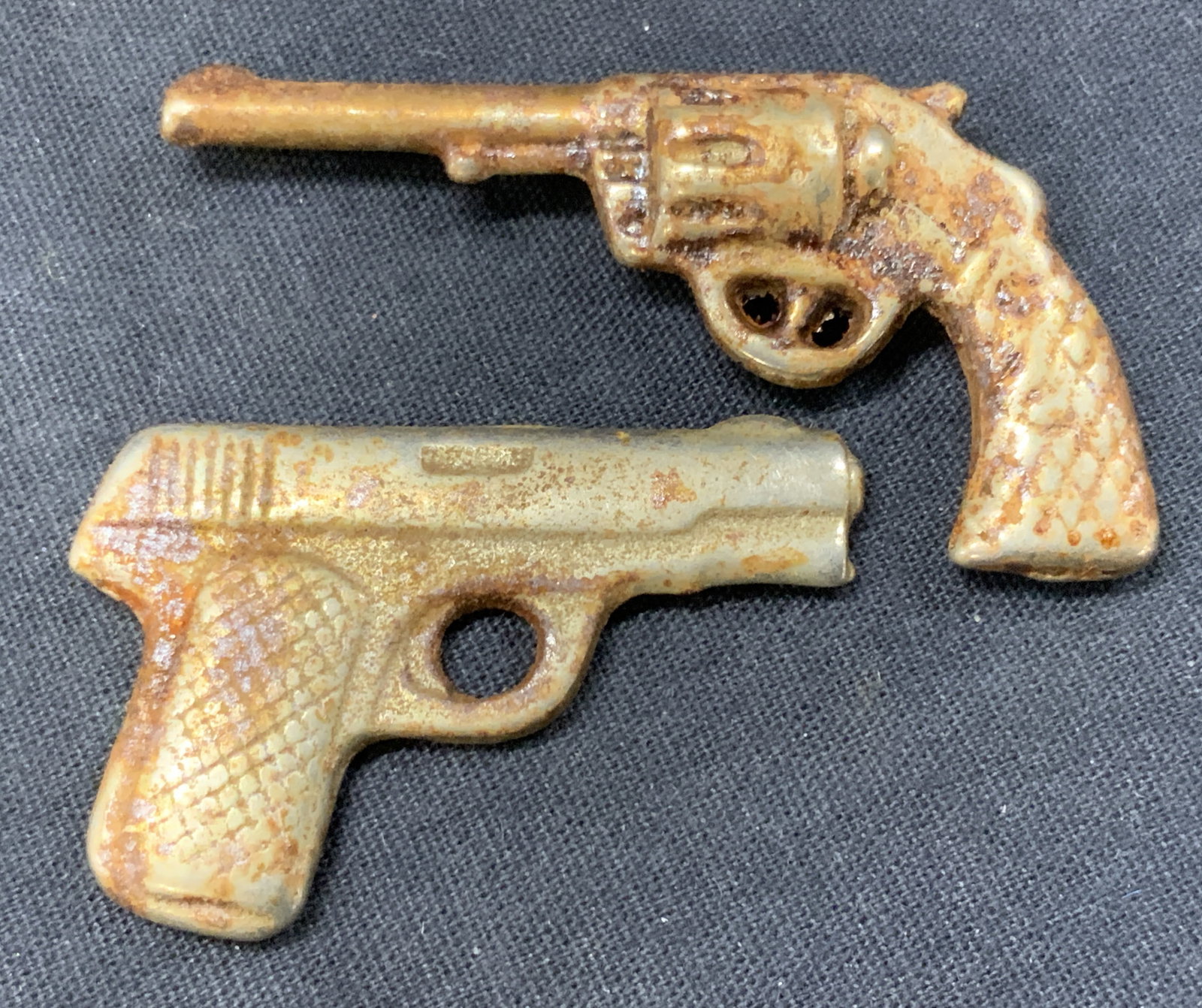 2 Vintage Miniature Metal Guns: Lot of 2 vintage, possibly antique metal miniature doll house guns. 1 revolver and the other a modern day 9/7 mm semi auto pistol. Approx 2.25 inches wide and 1 inch long. Evident residue and blemishe