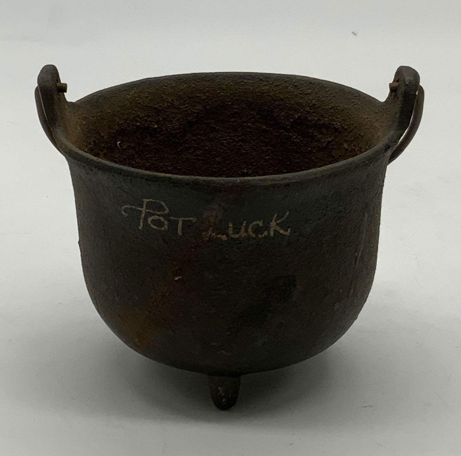 Vintage John Wright Cast Iron Pot Luck Cauldron: Vintage John Wright Inc cast iron cauldron, reads Pot Luck on body. Trademarked to underside. Measures approx. 3.5 x 2.75 inches. Surface wear including scratching and oxidizing observed. John Wright,