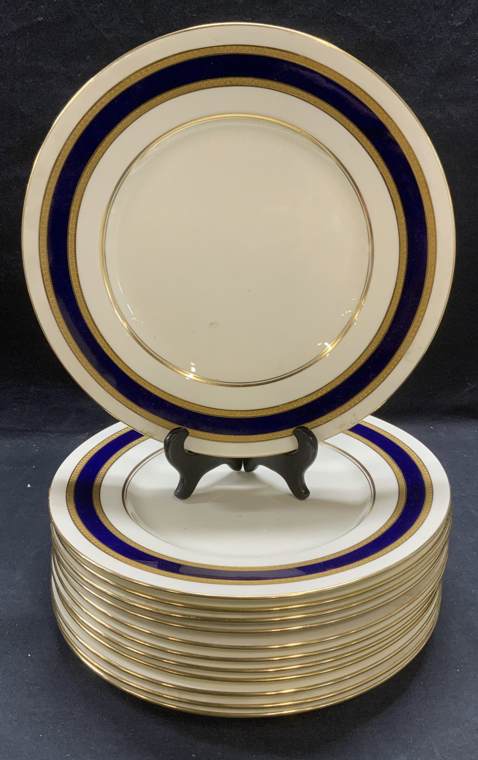 12 Vntg Royal DOULTON Gilt Porcelain Plates England: set of 12 vintage Royal DOULTON porcelain plated in white with cobalt blue and gilt borders. Trademarked to undersides. Made in England. Measure approx. 10.75 inches diameter each. All pieces have som