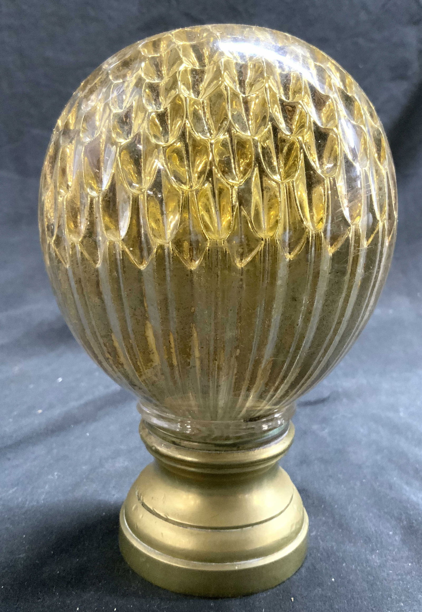 Vintage Art Glass & Brass Finial: Finial is glass with gold toned detail inside structure. Base of finial is brass. Shape has balloon form. Detail within glass has crater relief pattern detail. Piece measures approximately 6.25 inches