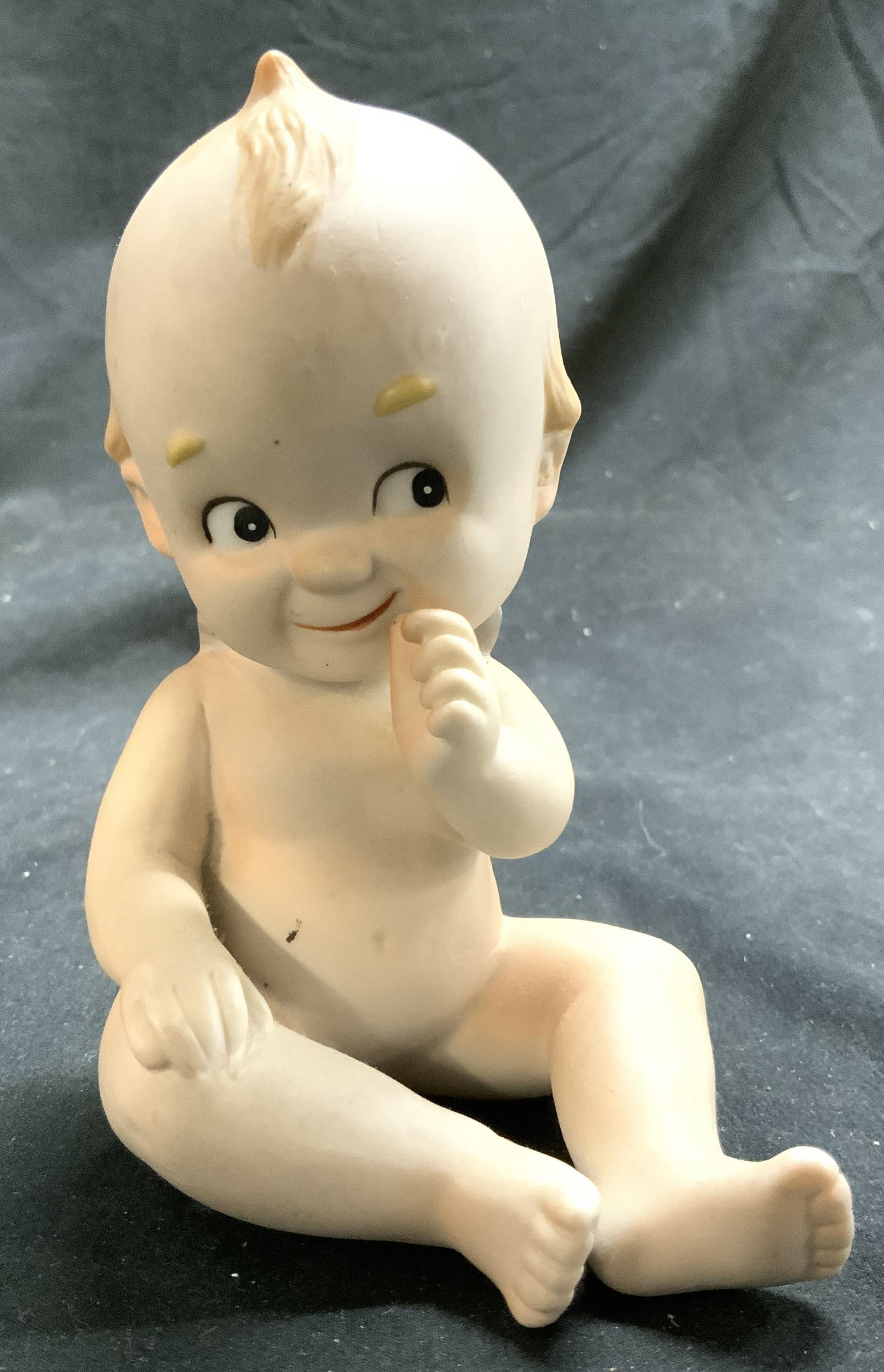 KEWPIE Vintage Porcelain Seated Baby Figure: Figure appears to be KEWPIE (no apparent markings). Piece is porcelain. Depicts a seated smiling baby. Baby figure is vintage. Measures approx 4.75 inches tall 4 inches deep 2.75 inches wide. Kewpie p