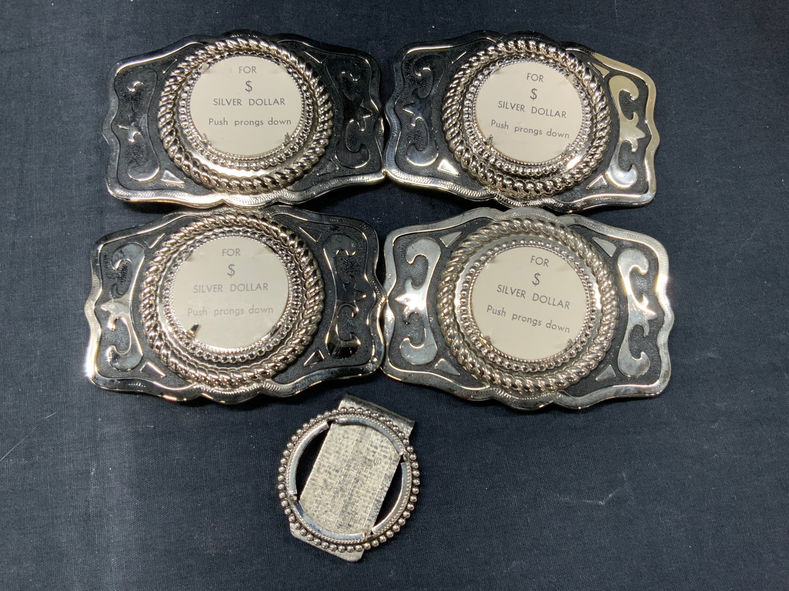 Set 5 Silver Tn Belt Buckles: Set of 5 make your own belt buckles with silver toned scroll motifs over copper metal, center of buckles has paper that reads for $ Silver dollar, push prongs down. And 1 money clip with an empty inse