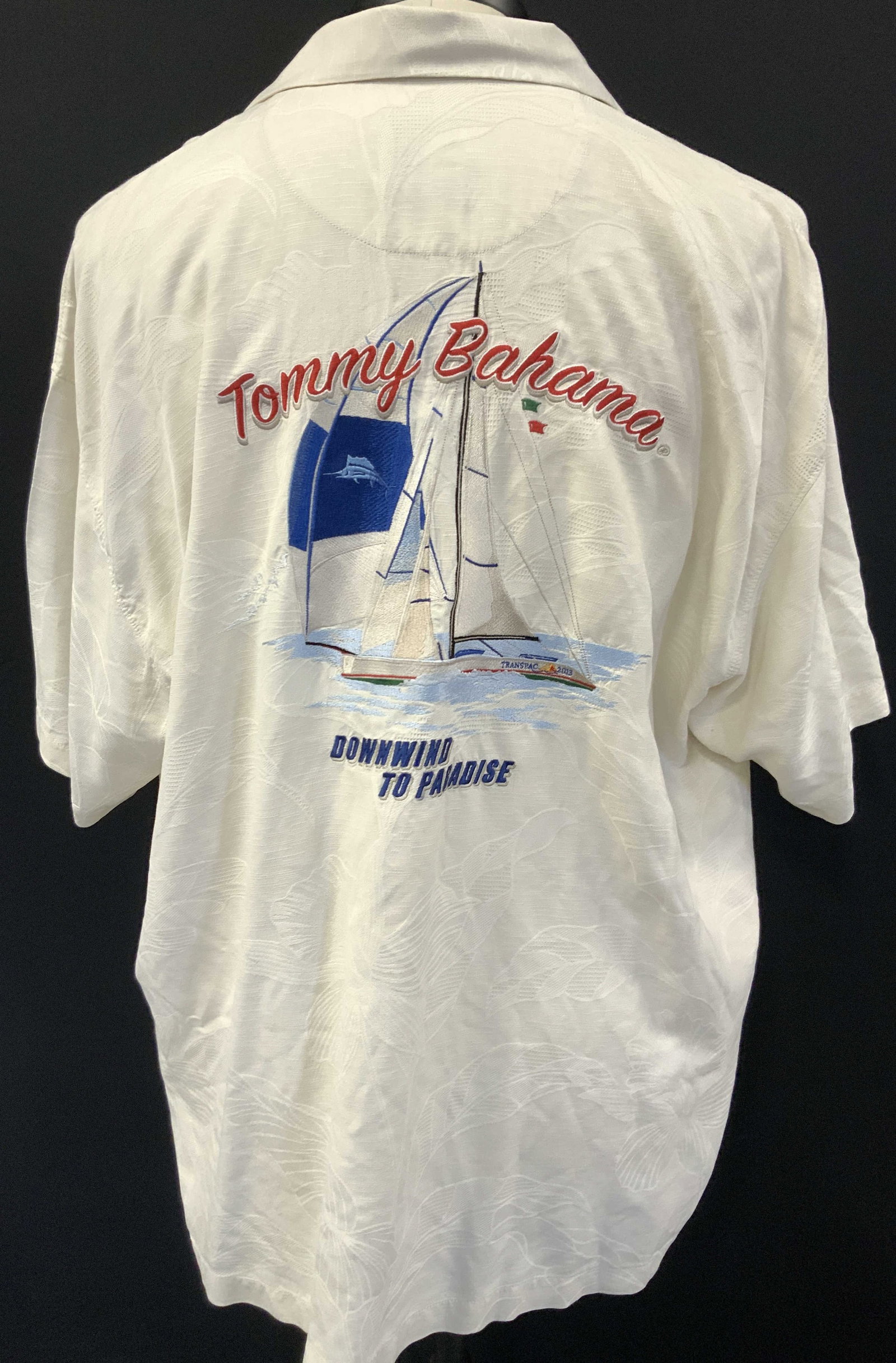 Tommy Bahama Silk Embroidered Sailing Shirt: Tommy Bahama, size XXL, silk and rayon button up shirt. Embroidered on backside with a sail boat and text reading Downwind to paradise Sleeve measure 6.5 inches from underarm inseam, torso measures 31