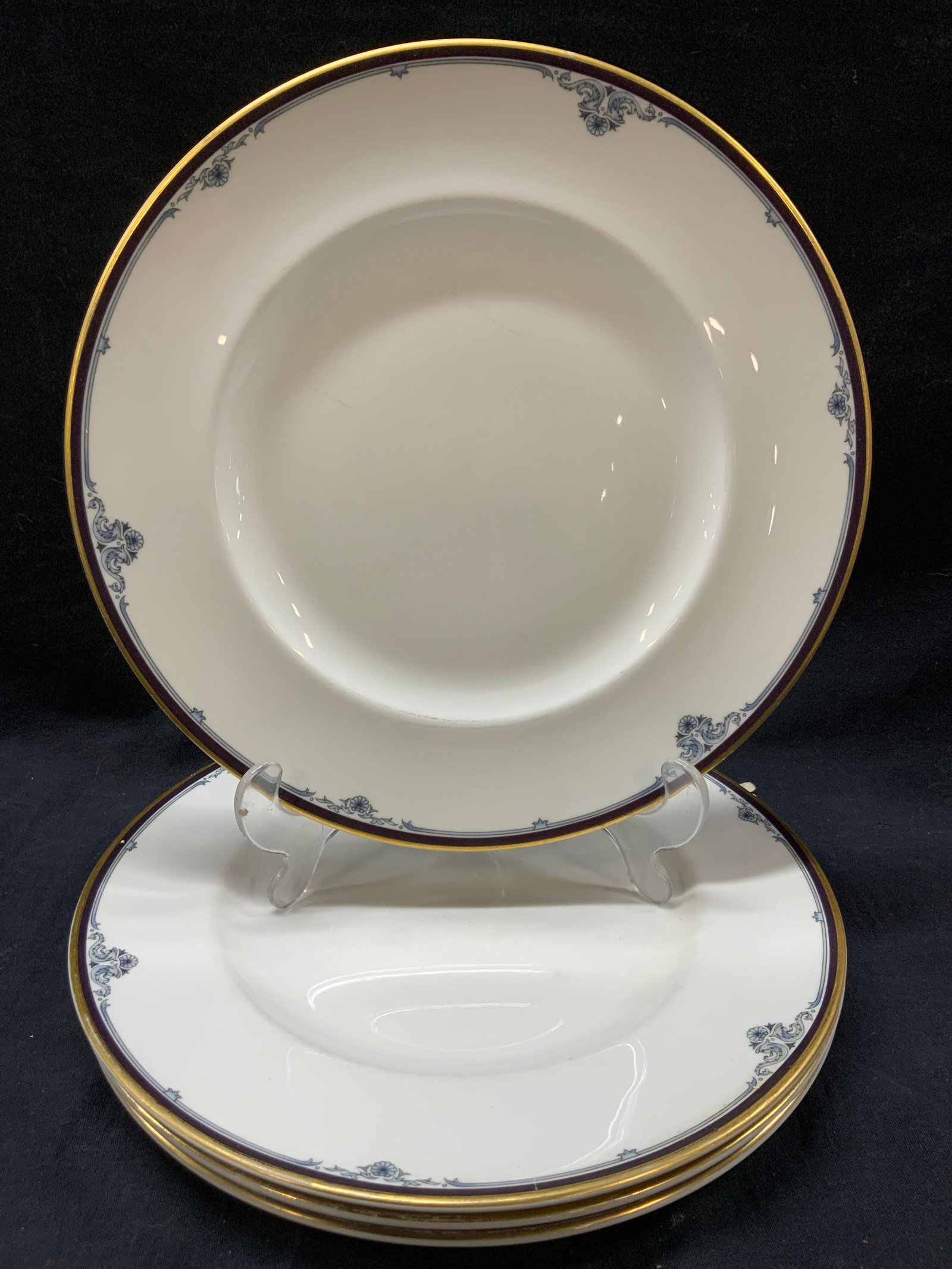 Set 4 Royal Doulton Gilt Princeton Dishes: Set of 4 Royal Doulton Dishes with gilt rims and blue floral motifs on edges. Marked on underside Princeton. Approx 10.75 inch diameter. Evident wearing to center of dishes due to age and use and wear