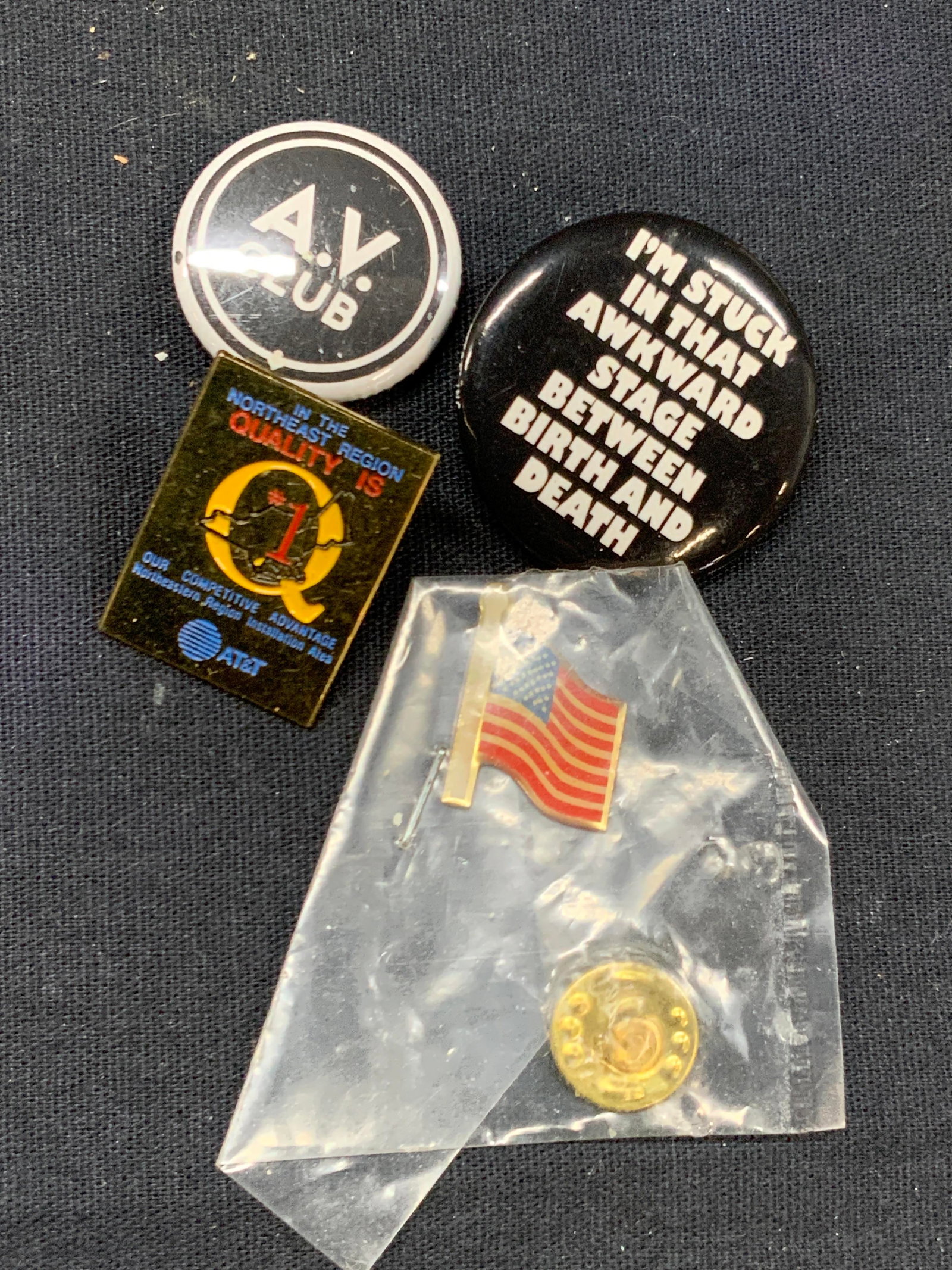 4 Vintage Enamel & Lapel Pins: Lot of 4 vintage pins. 2 pins with pin backings, 1 reads the AV Club and other reads Im stuck between that awkward stage between bird and death. An enamel AT&T pin and 1 American flag pin. Largest pin