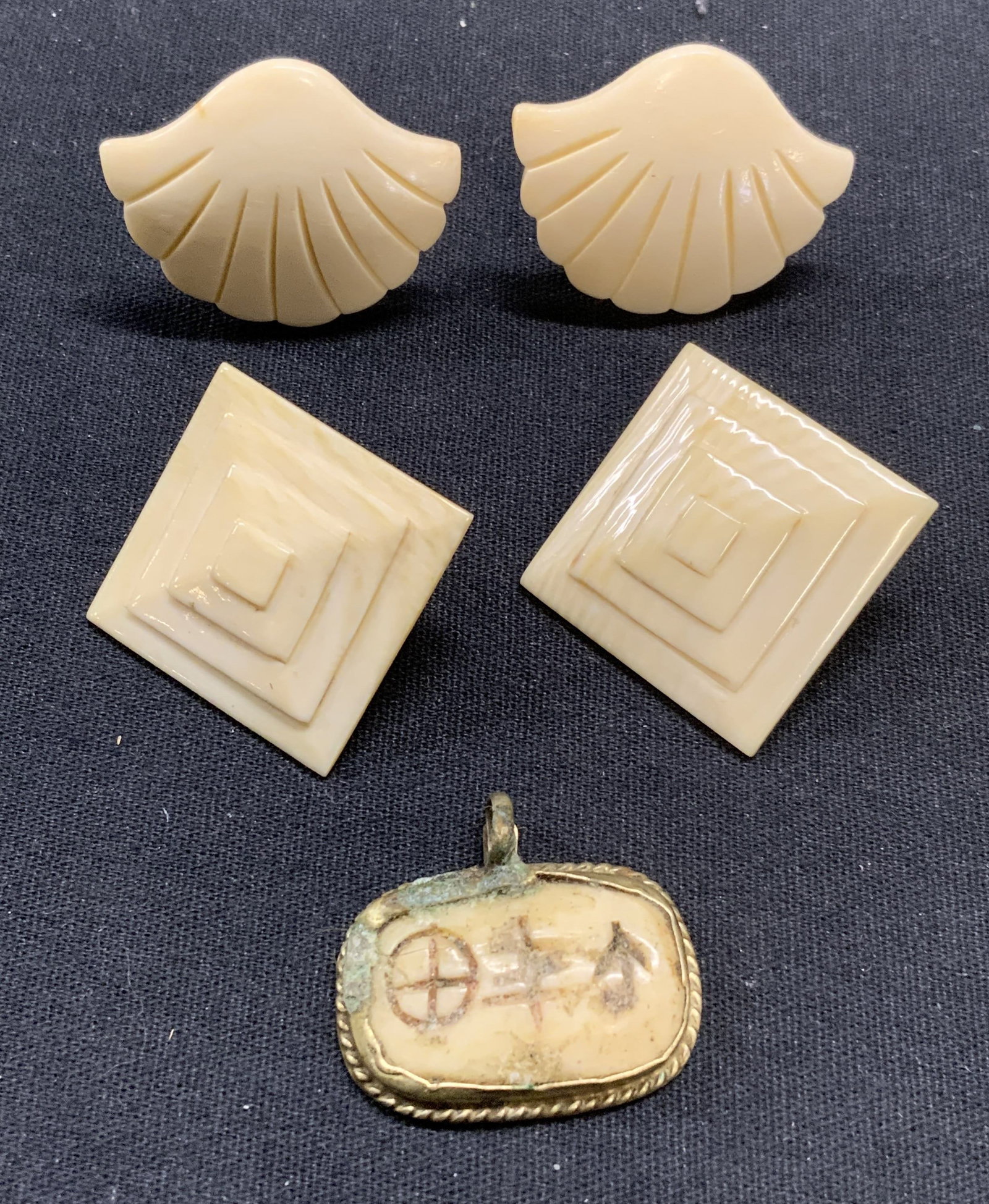Lot 3 Carved Bone Earrings & Pendant: Lot of 3 jewelry pieces. 2 pairs of Carved bone earrings with post backings. Larger pair measure approx. 1 3/8 inches wide. Vintage carved bone pendant. Measures approx. 7/8 x 1.25 inches. All pieces 