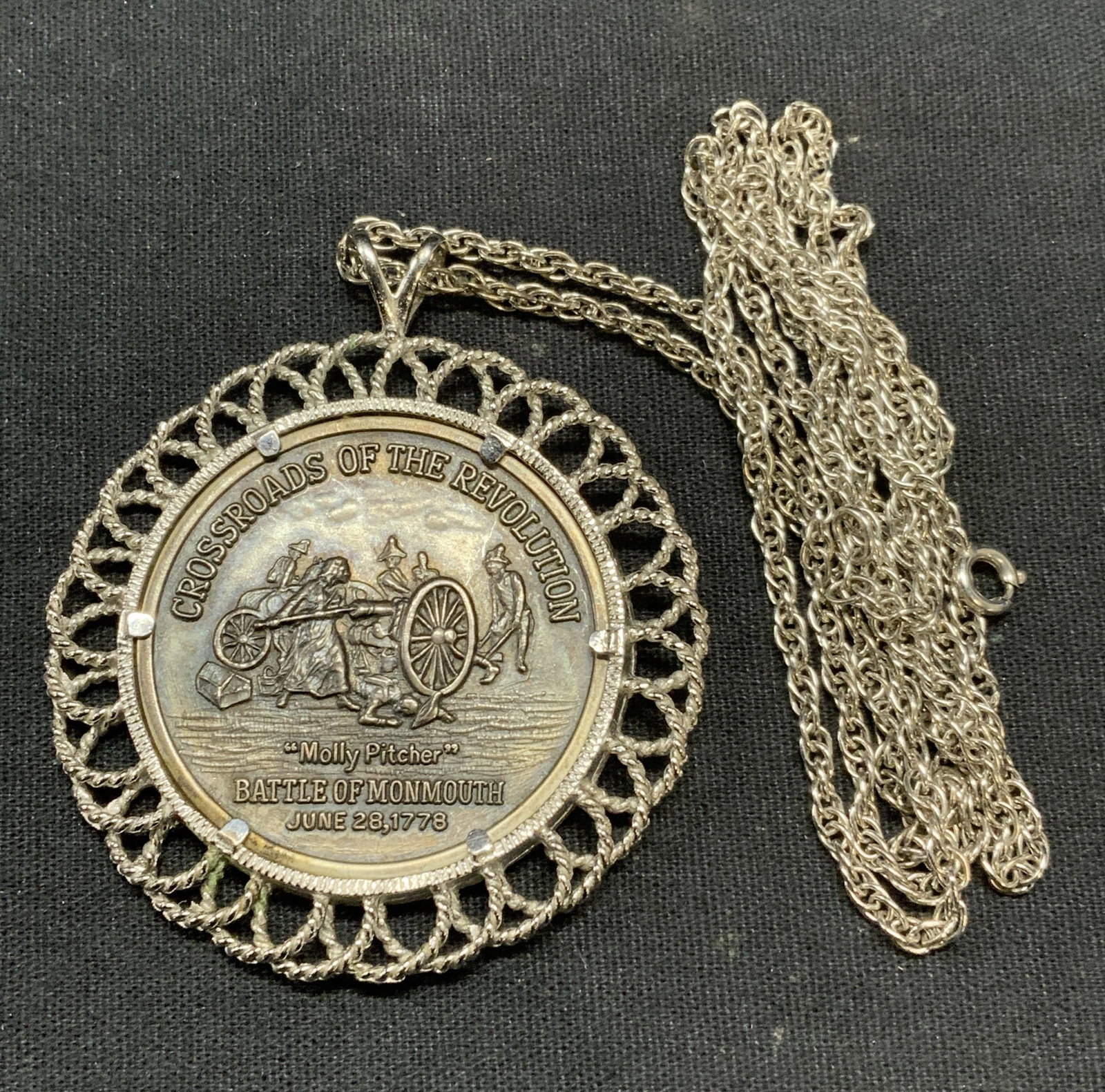Sterling Silver Necklace & US Revolution Pendant: Sterling silver chain necklace. Marked sterling on clasp. Drop length approx. 14.75 inches. Total weight .35 ozt. Pendant with Crossroads of the Revolution Molly Pitcher pendant. Measures approx. 2 in