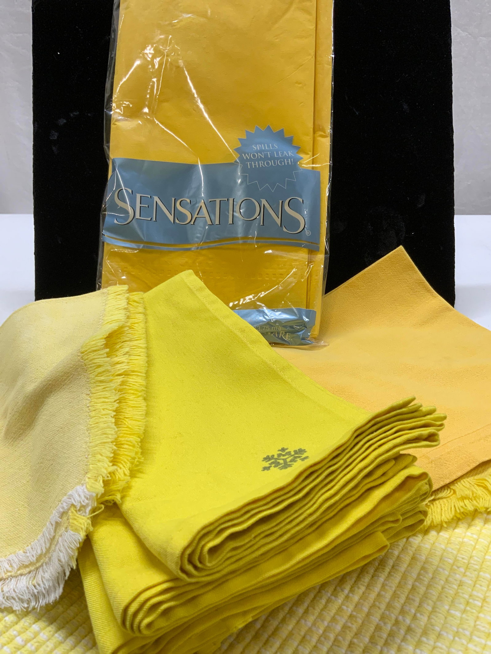 Grp 13 Yellow Table Linens, Party Tablecloth NIP: Group of all cotton and hues of yellow table linens. Set 7 napkins with snowflake, 19.5 x 19.25 in. 2 thick cotton rag rug style placemats with fringe, 16.25 x 11 in. Deep Saffron cotton napkin, 2 tex