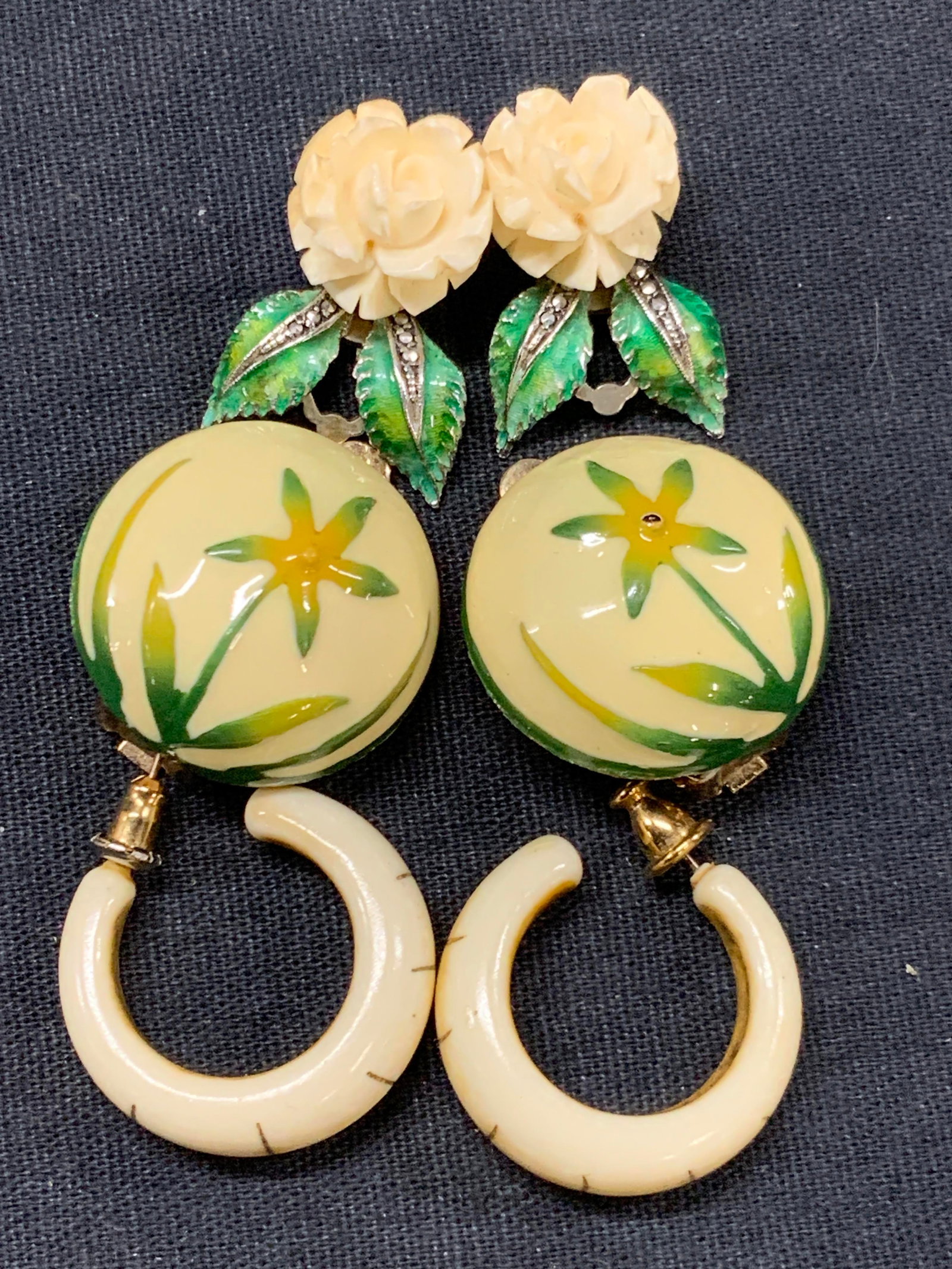 3pr Earrings, Hobe, Monet, Sterling Silver Germany: Lot of 3 pairs of earrings. 1 pairs marked Sterling, made in Germany with carved bone roses and green enamel leaves, approx 1 inch long. 1 pair of Hobe enamel clip on button earrings with floral motif