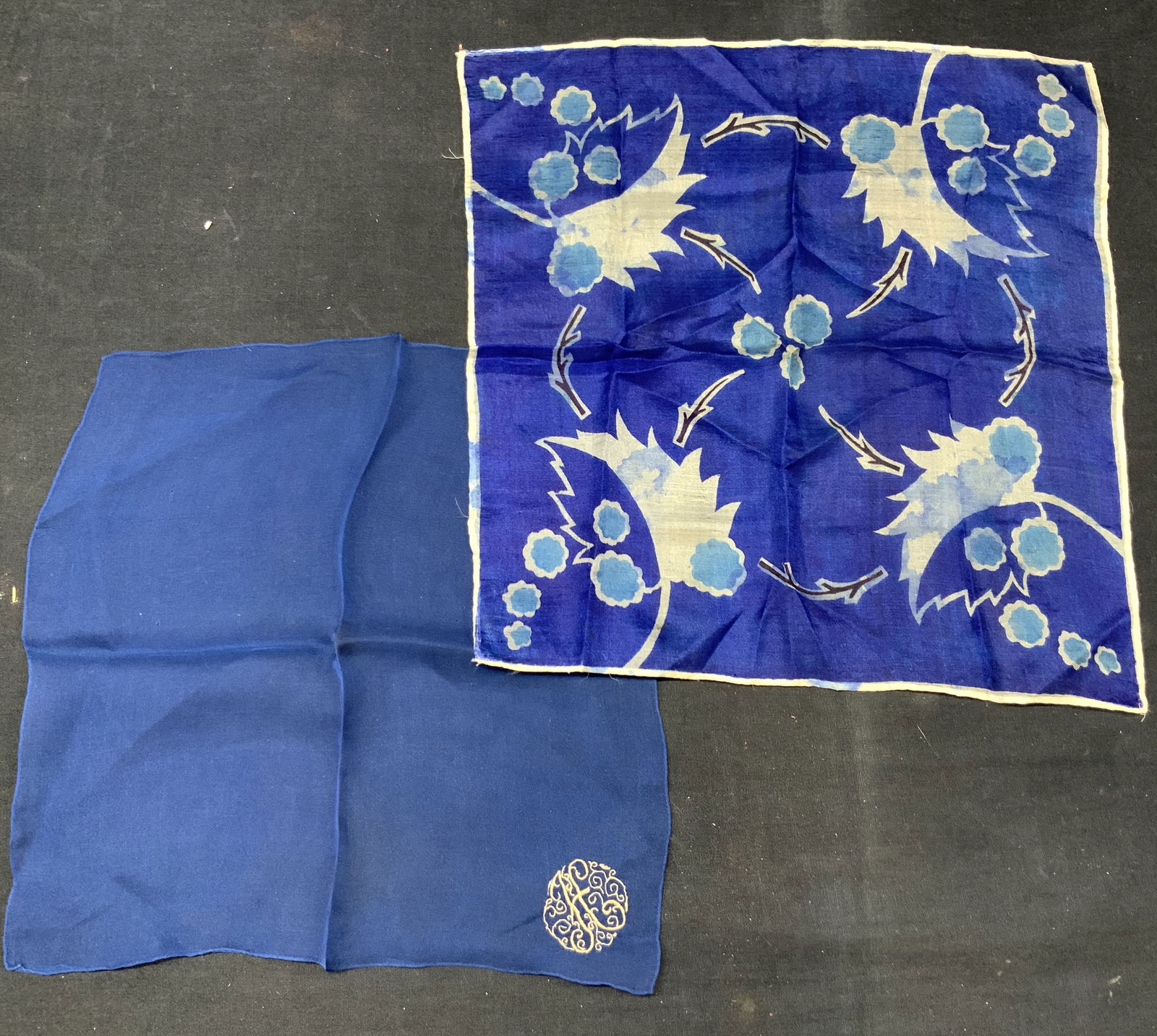 2 Vintage Silk Monogrammed Handkerchiefs: Lot 2 blue toned handkerchiefs. 1 silk with blue and white accents in floral motifs approx 11 x 11, the other a solid blue with gold embroidered monogrammed initial on corner, approx 9.5 x 10 inches m