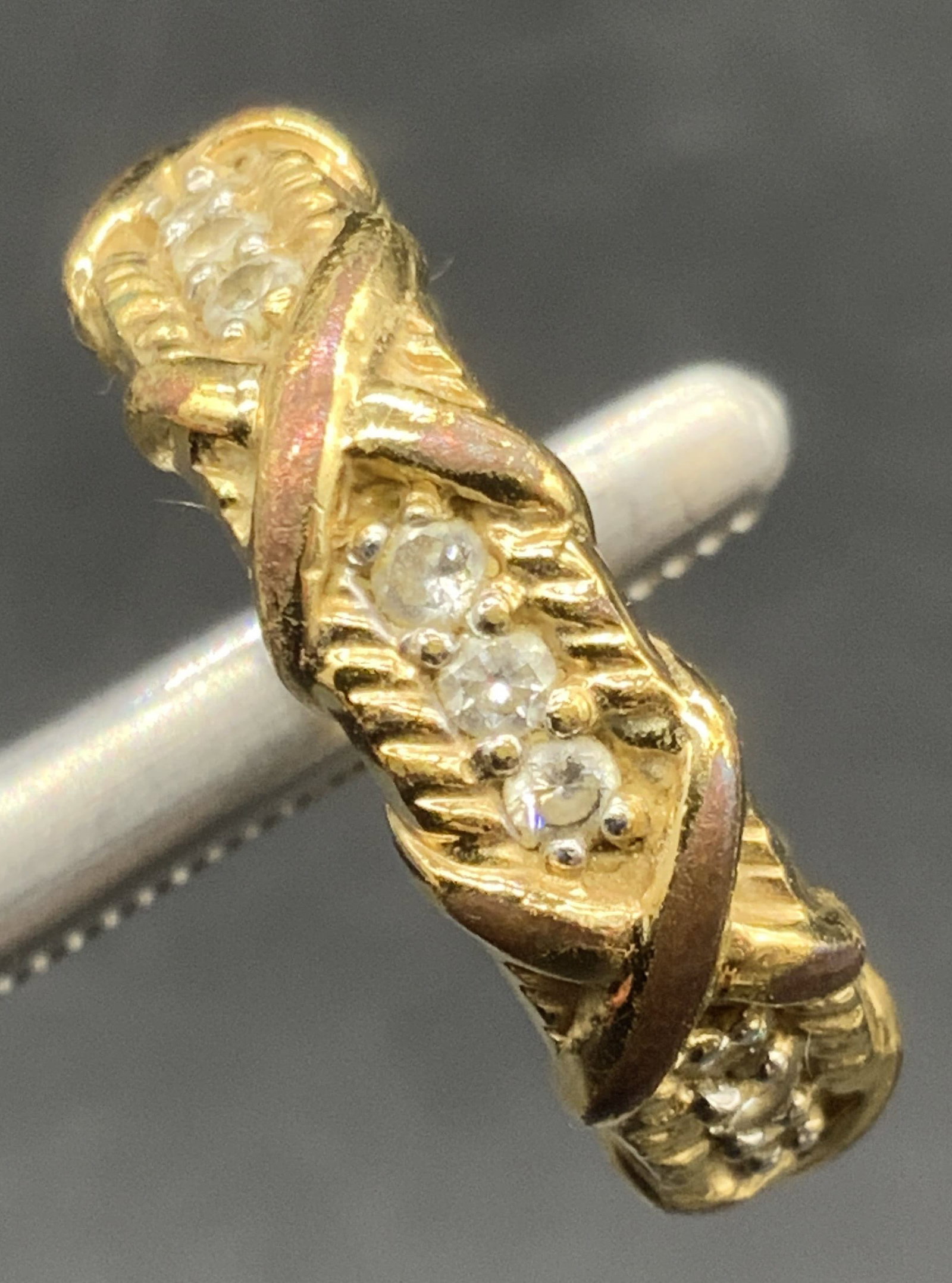 JBK Signed Faceted Crystal Gold Tone Metal Ring: A gold tone metal ring featuring faceted colorless crystals. Raised metalwork designs throughout. Ring size approx. 9. Interior signed JBK. Some discoloration and surface wear present. Appears to be a