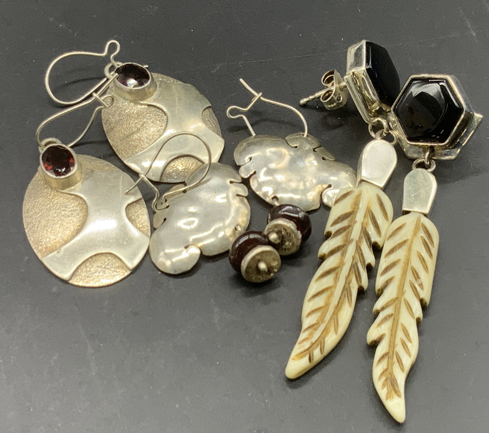 3 STERLING SILVER Vintage Earrings, SAJAN &more: One pair of sterling silver earrings features a deep red hued faceted stone, gem tester tests for garnet, and is stamped 925 to reverse. Measures approx. 1L x .75W in. The pair of earrings featuring a