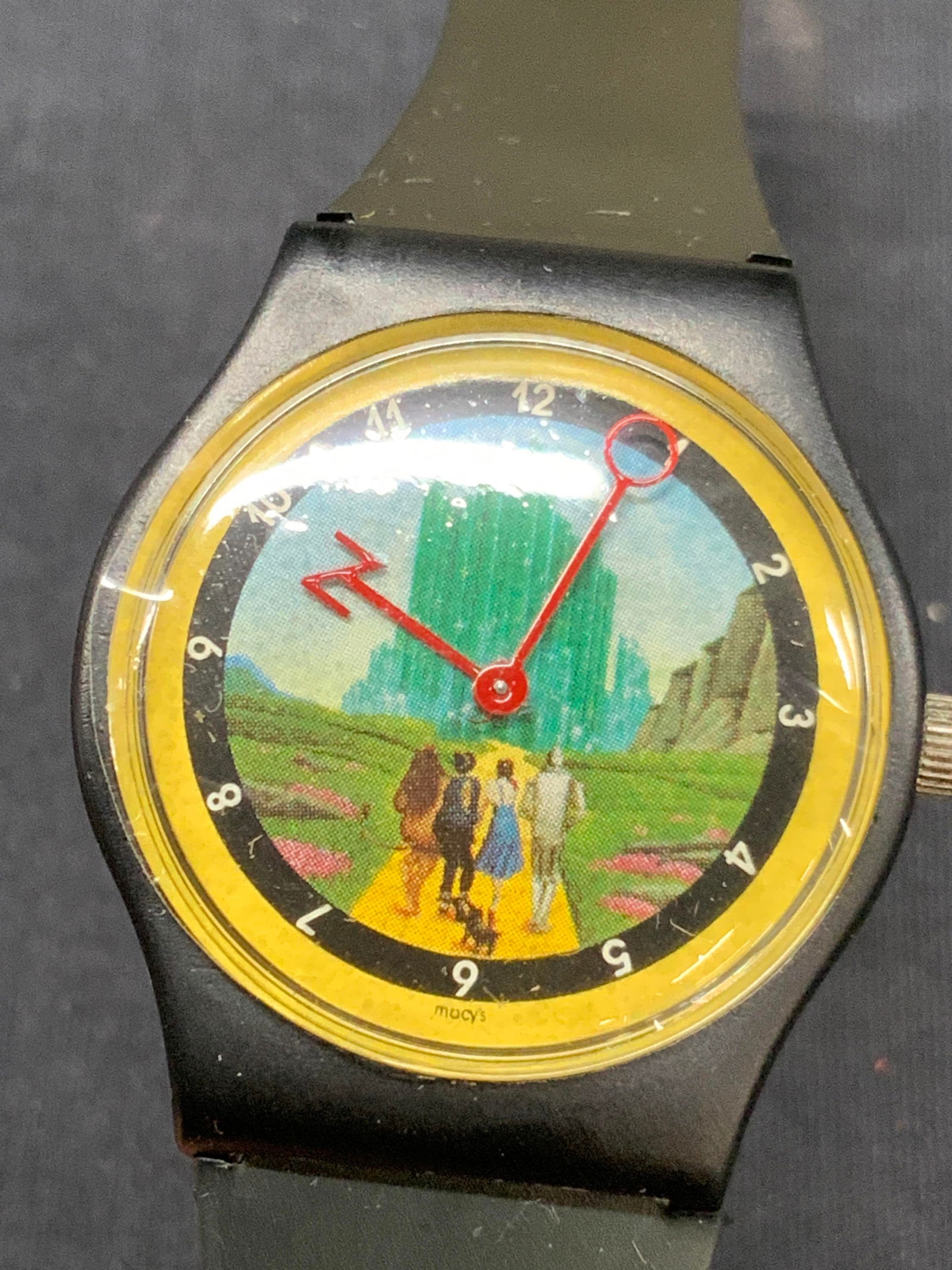 Vtg Macys Oz Time Wizard Of Oz Wrist Watch: Vintage Wizard of Oz Wrist watch, comes in container marked Oz Time, Macys. Clock face depicts Dorothy the tin man, the cowardly lion and the scarecrow walking towards the Emerald City, the hands of t