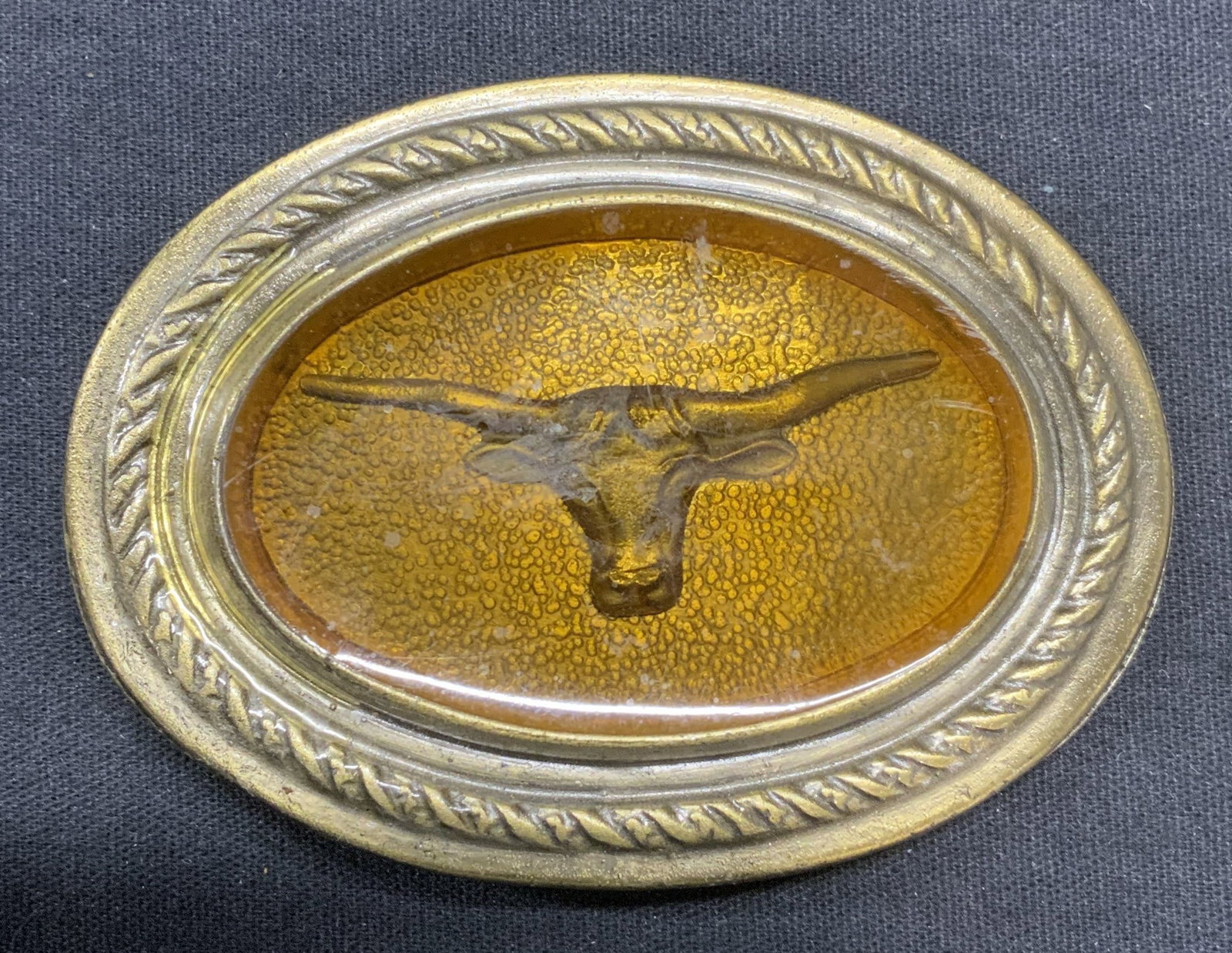 Vintage Gold Tn Longhorn Cow Belt Buckle: Vintage gold tone longhorn cow belt buckle with orange resin. Decorative embossed border. Measures approx. 3.25 x 2.5 inches. Piece has weight. Some surface wear including scratching observed. Belt bu