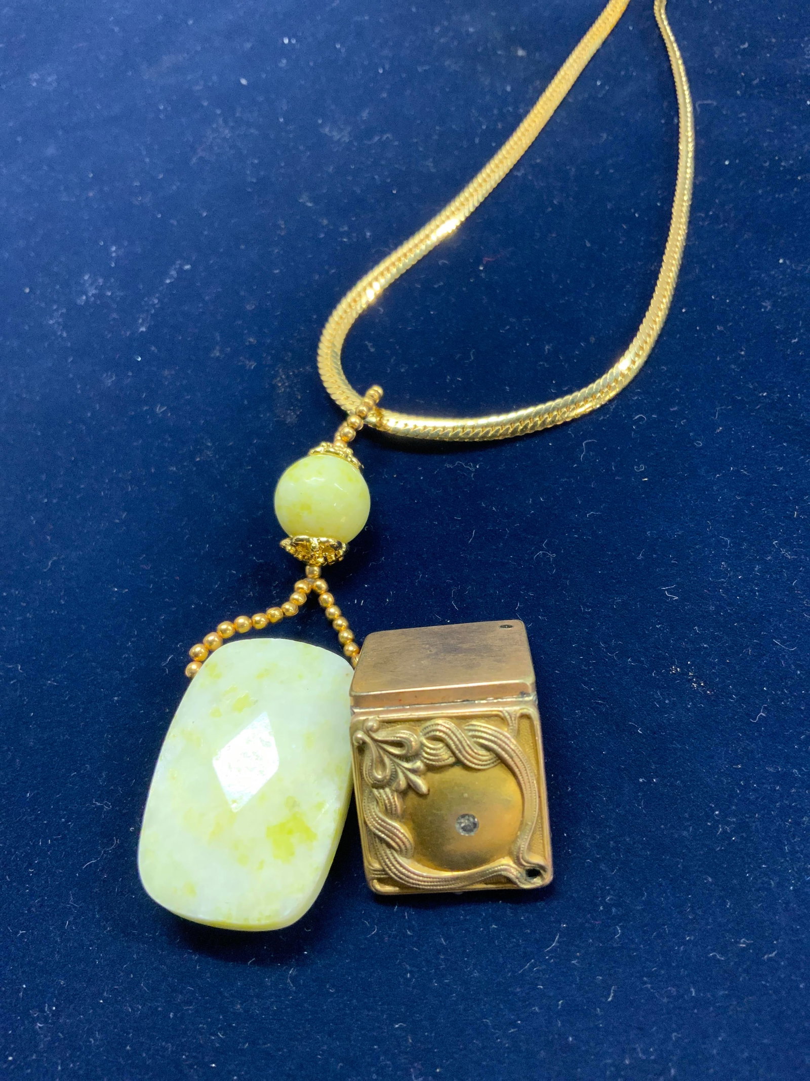 2 Stone Pendant Necklace & W.H. Co Art Deco Locket: Gold tone bone chain necklace with faceted stone pendant ( possibly Lemon Chrysoprase) pendant measures 1.25 x .75 in. Approx 80 cts. Necklace drop is 7 in. Antique signed W.H. Co gold tone Art Deco h