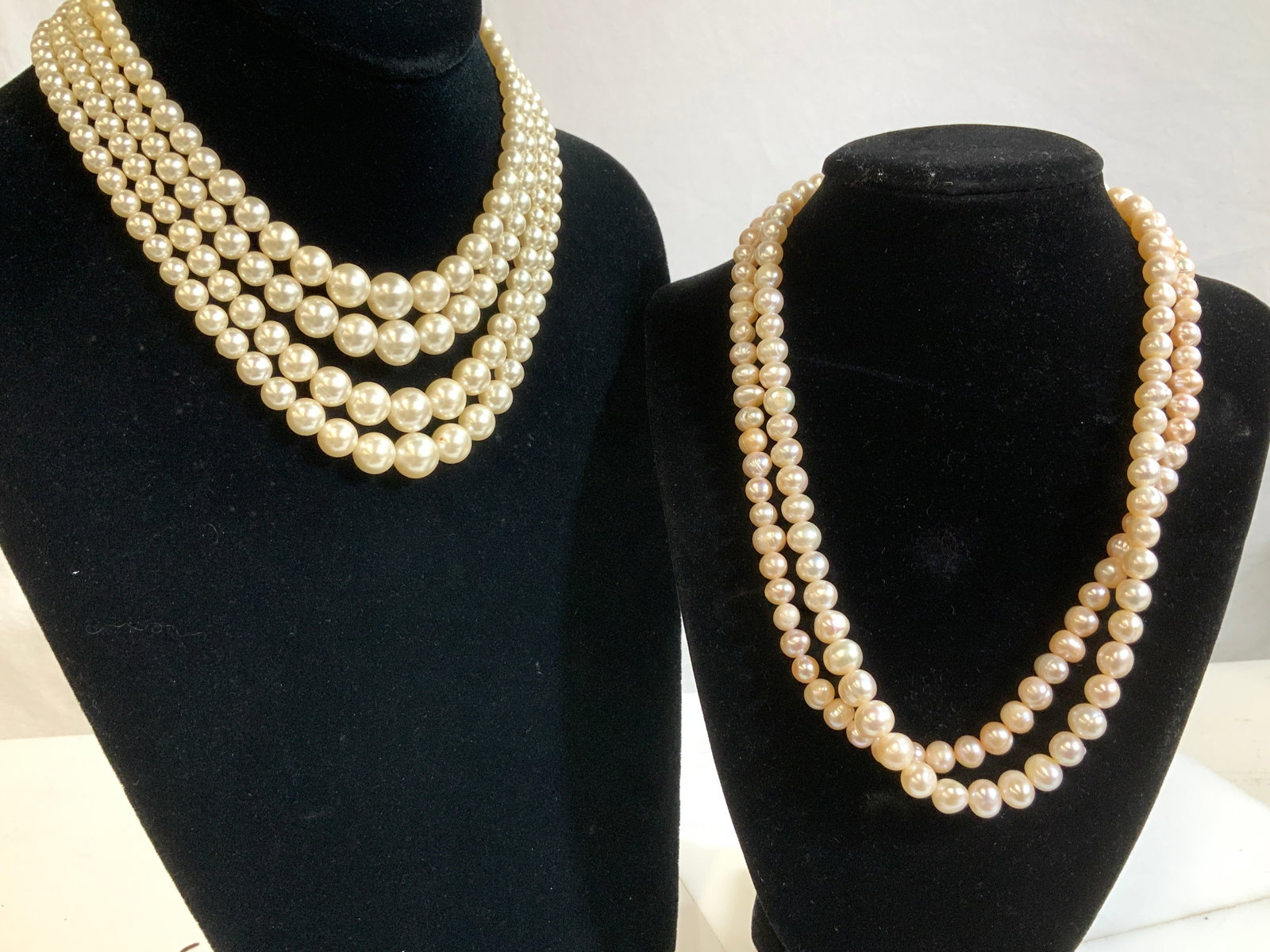 Lot 3 Cultured Pearl Necklaces, Costume Pearls: 415 carats of cultured pearls. 2 pearl necklaces- light blush pink cultured pearl necklace with twist clasp. Uniform pearl beads in size, luminous iridescence.17 in. Long, 7 in. Drop. Off white cultur