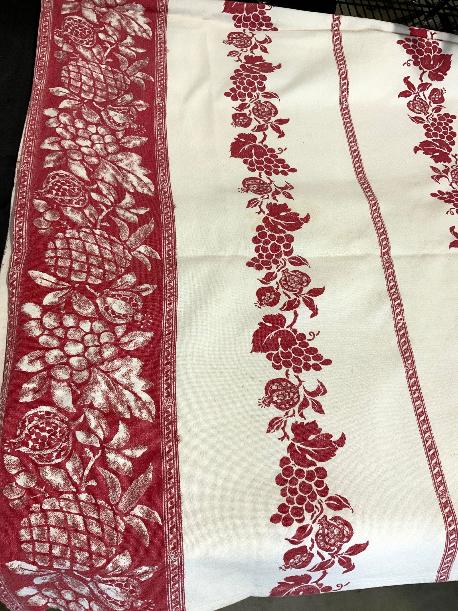 Romagna Mirabello Italian Fruit Cotton Tablecloth: Heavy cotton tablecloth in white and red. Red fruit decor- grape vine leaf, pineapples and pomegranates. Tablecloth measures 61 x 65 in. Does have blemishes consistent with use and exposure. Labeled o