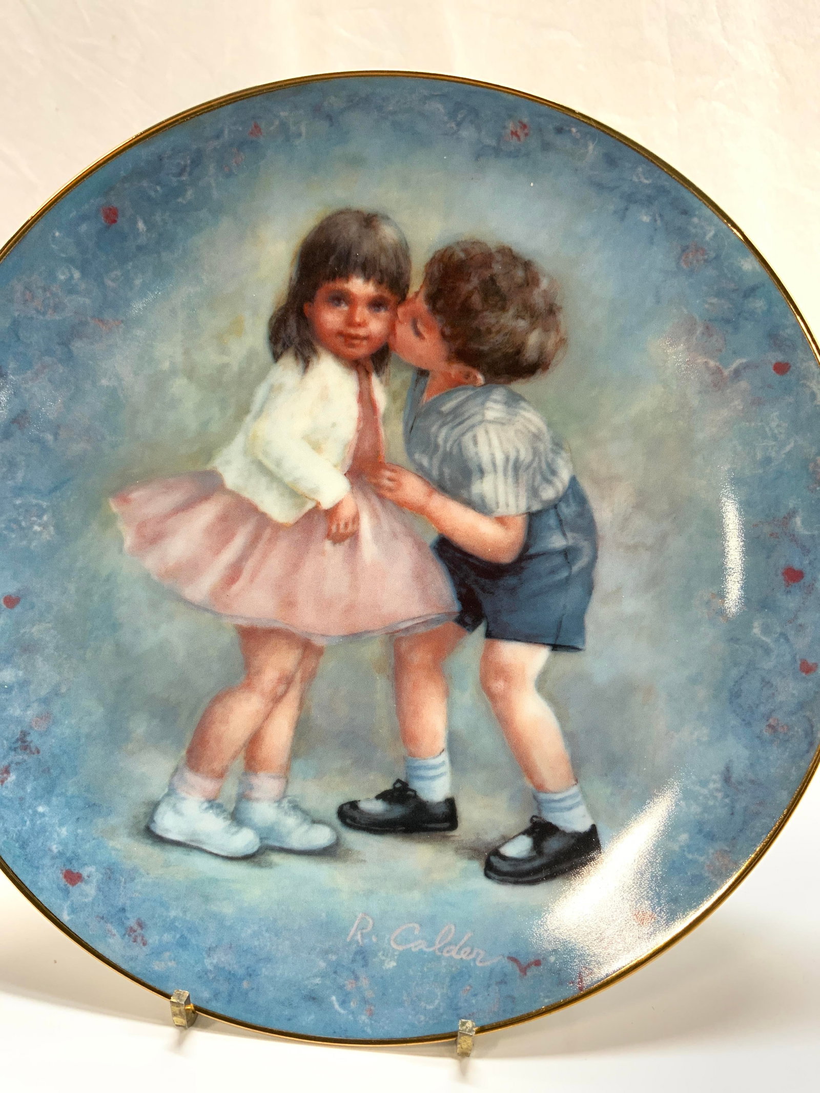 Rosemary Calder Calhoun Ltd Ed Porc Display Plate: Hand painted display plate, original design and painting by Rosemary Calder, signed lower right, boy kissing girl, tilted FIRST KISS , c. 1981 limited edition for Calhouns Collectors Society. 8.5 in.,