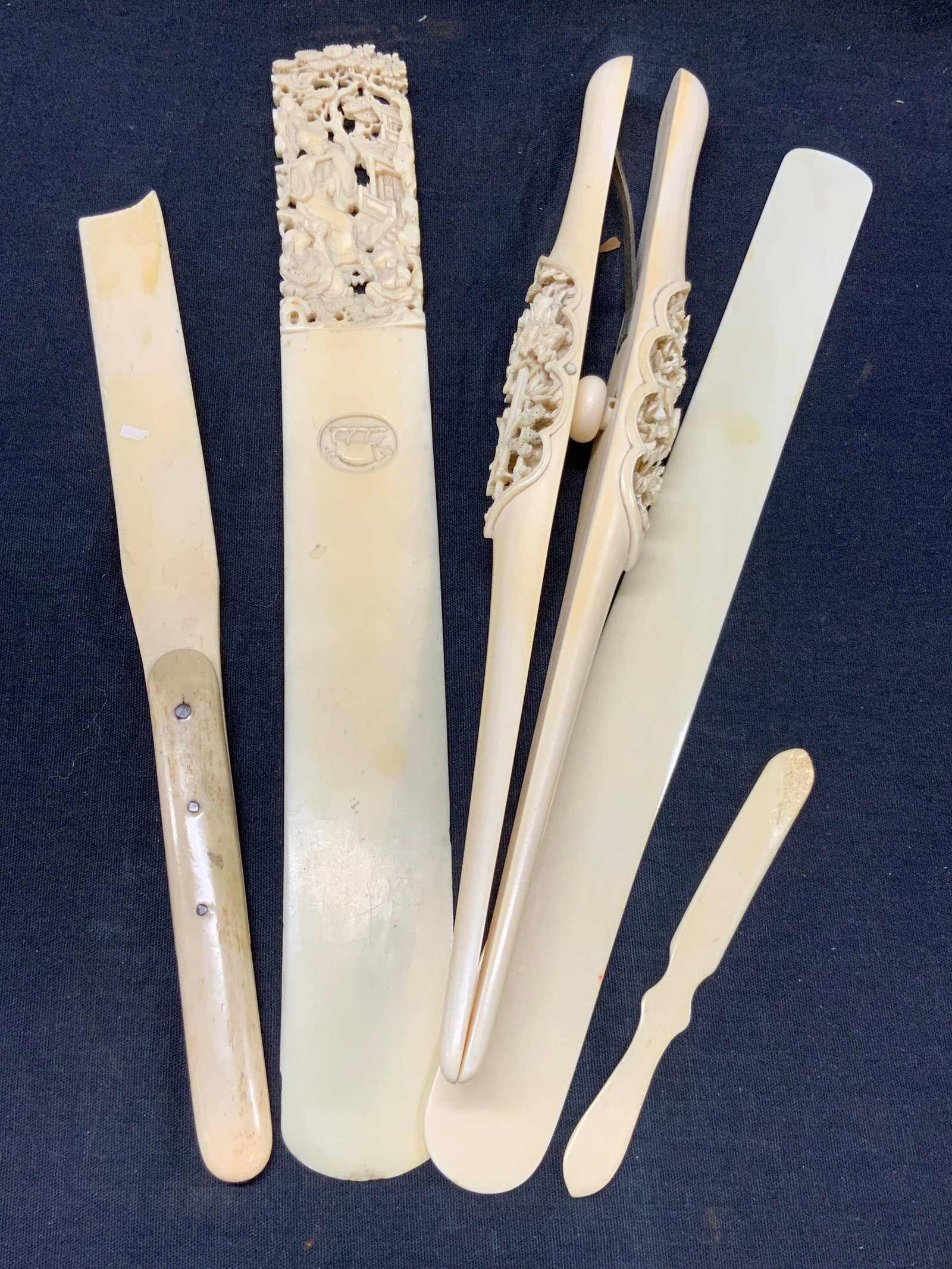 Lot 5 Carved Bone Asian Desk Accessories: Lot of 5 carved Asian desk accessories, letter openers and clips. 3 letter opener. 1 carved with ornate handle that depicts an adult playing a flute with children around, and etched with a boar on ope