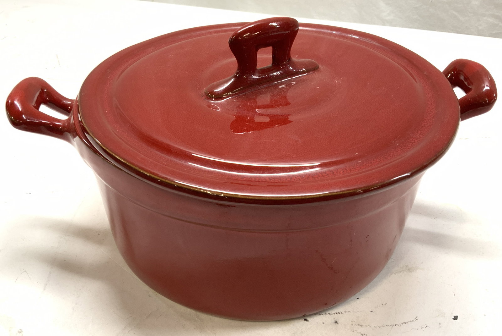 Virginia St Stoneware Dutch Oven, Italy: Red stoneware Dutch oven, made in Italy ,hallmarked Virginia St Italy. Measures 10 in. Diameter, 13 in. Wide with handles, app.4.5 in. Deep. ( without lid) . Some glaze crazing consistent with use. Ki
