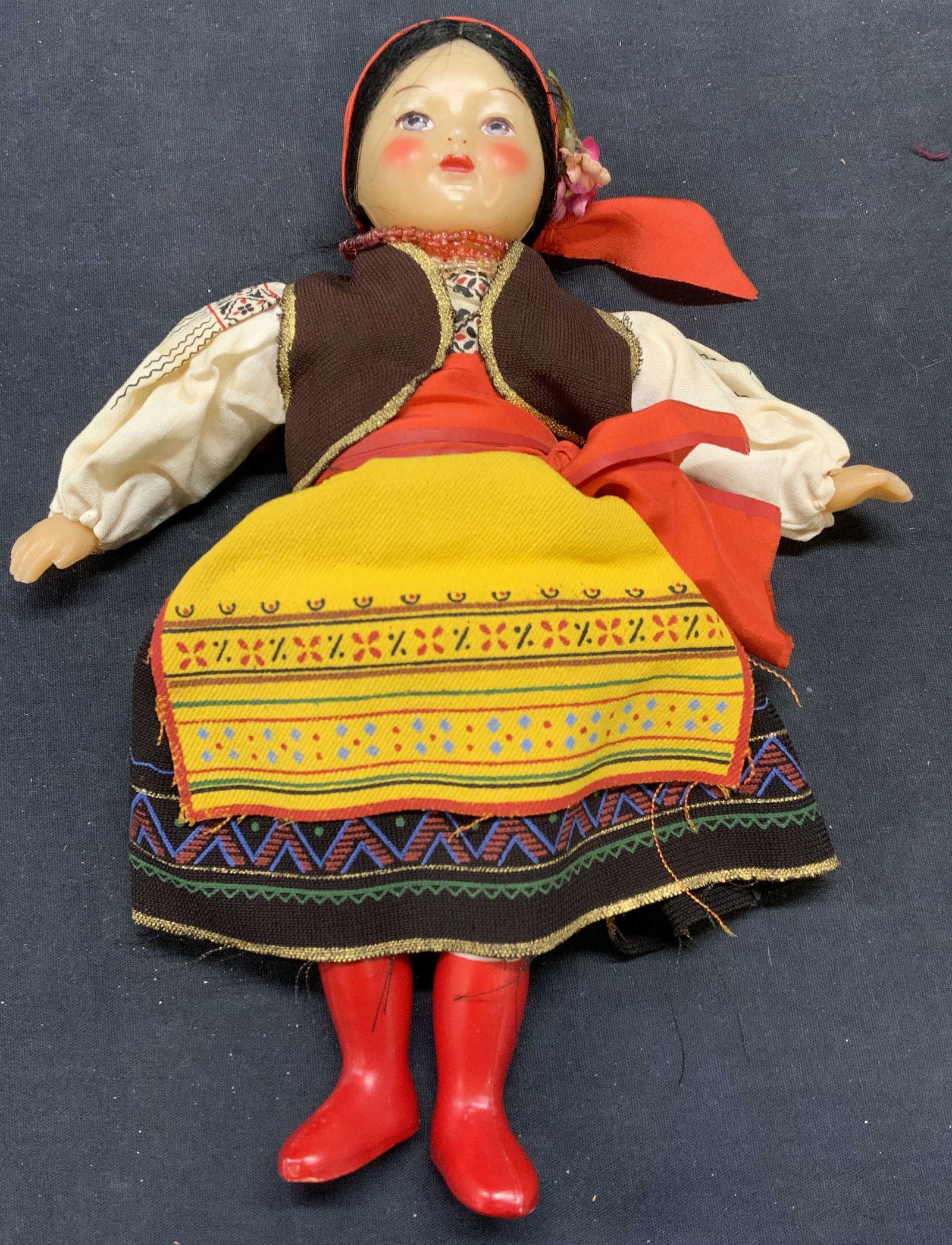 Vintage Fashion Doll: Vintage fashion doll with head scarf and geometric print skirt and apron. Measures approx. 10.5 inches long. Composite material and fabric. Some wear to material consistent with exposure. Doll, vintag