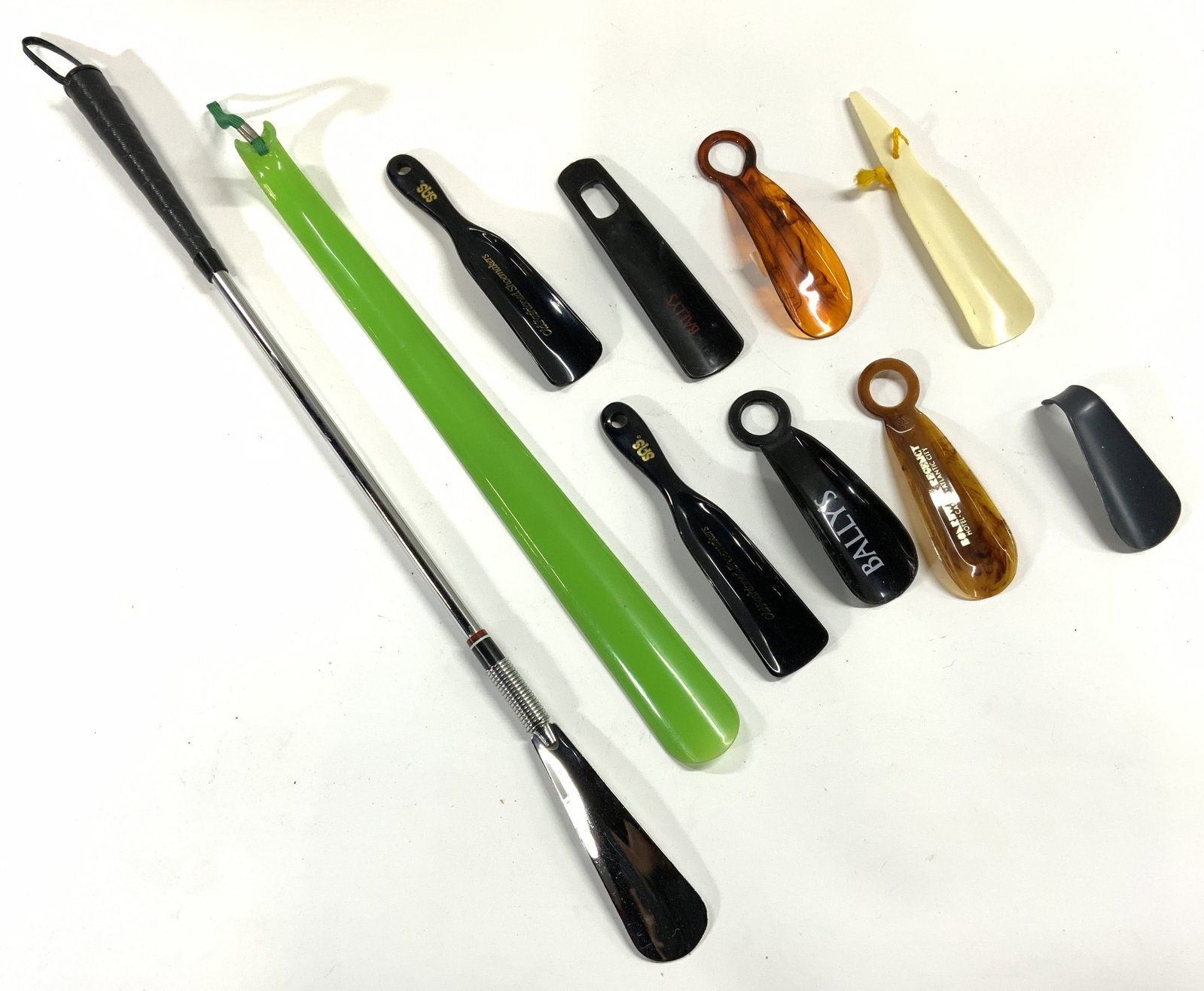 Lot10 Metal&Resin Shoehorns SAS, Ballys & Boardwalk+: Lot includes 1 metal & 9 shoehorns which appear to be resinous possibly plastic. Trademarks Include SAS OLD FASHIONED SHOEMAKERS, BALLYS, & BOARDWALK REGENCY. Largest shoehorn measures approximately 2
