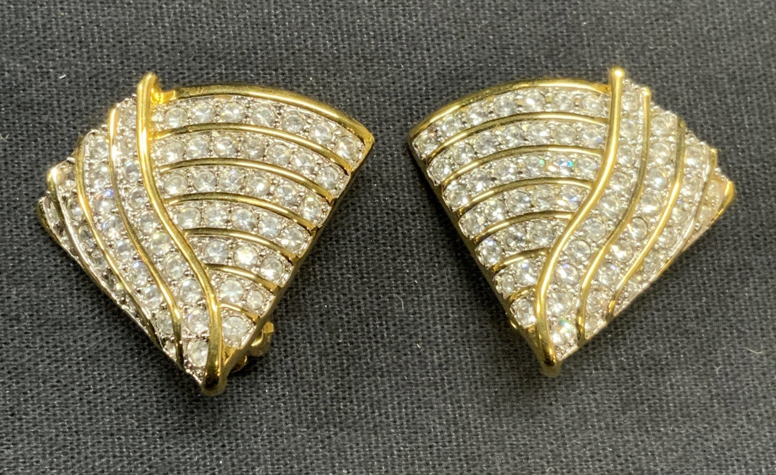 Swarovski Vintage Gold Tone Crystal Earrings: Signed Swarovski vintage gold tone crystal decorated clip on earrings. Signed to underside. Measure approx. 1 1/8 x 1 3/8 inches. Some scratching observed. Estate jewelry, costume jewelry, cocktail je