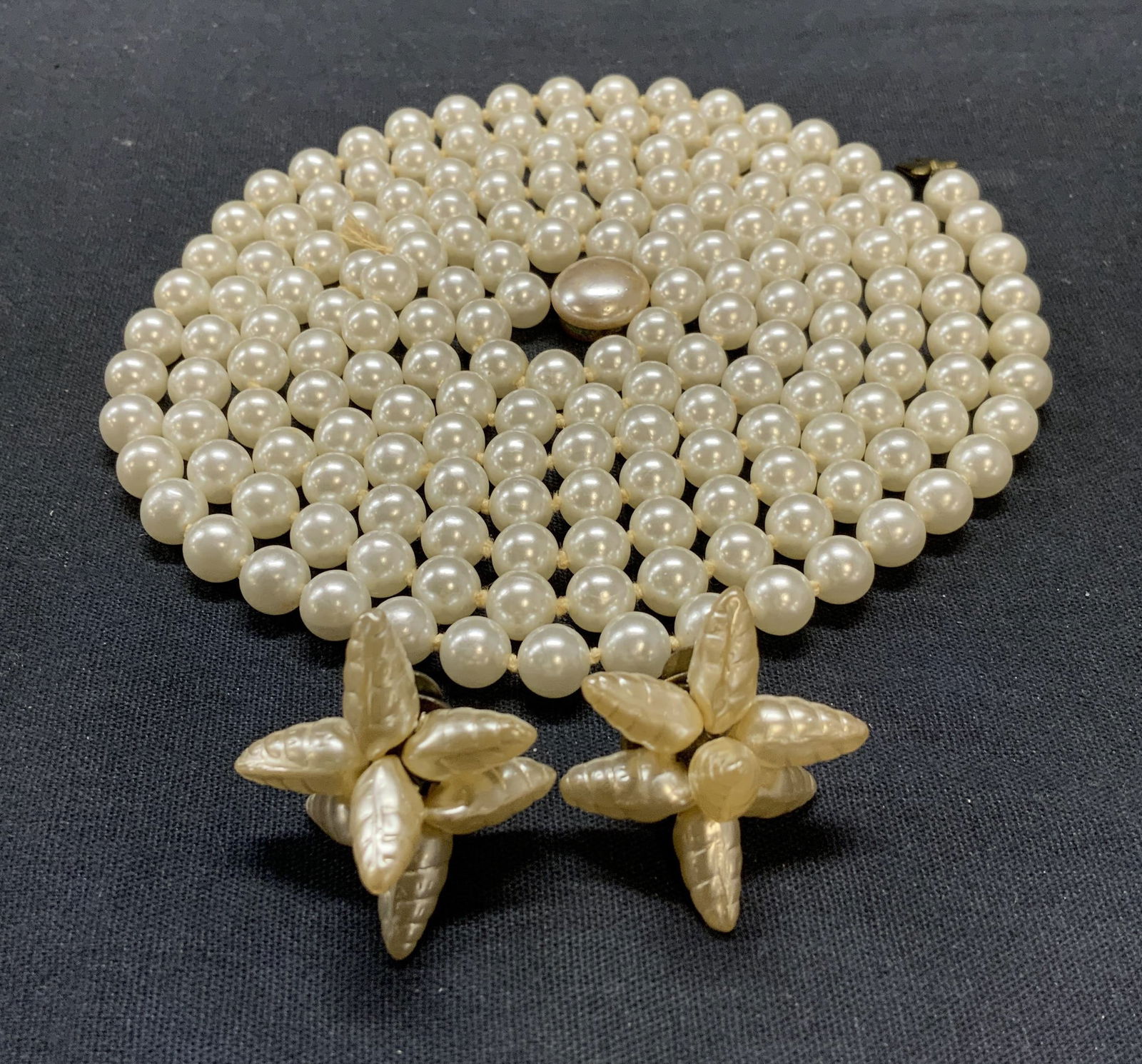 Lot 2 Faux Pearl Necklace & Shell Earrings: Lot of 2 vintage jewelry pieces. Faux pearl beaded necklace on double knotted string. Drop length approx. 29.5 inches. Shell bead3d clip on earrings. Measure approx. 1 inch wide. Both pieces have surf