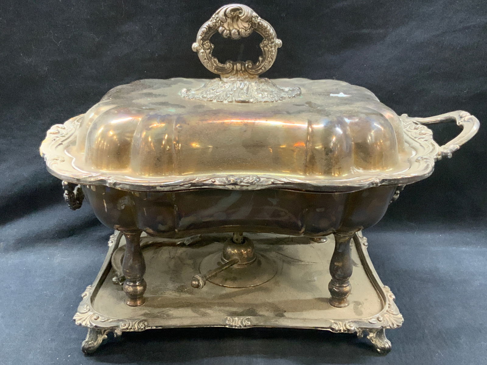 Vintage Silver Plate Chafing Dish: Vintage silver plate over brass chafing dish with removable insert and oil burner, scrolled feet and ornate design on corner and edges . Approx 12 inches tall and 16 inches wide. Evident repair needed