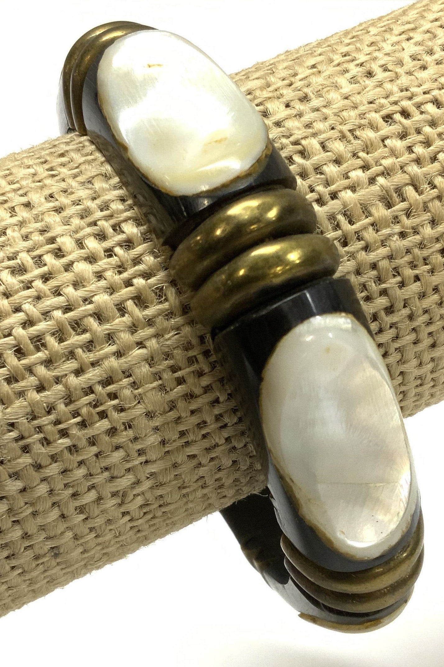 Artisan carved Animal Bone w MOP Bangle Bracelet: Hand crafted bangle bracelet , carved animal horn with mother of pearl shell between brass half circle ornaments. Mother of pearl is 1 in long, glued to the indentations of the horn carving , bracelet
