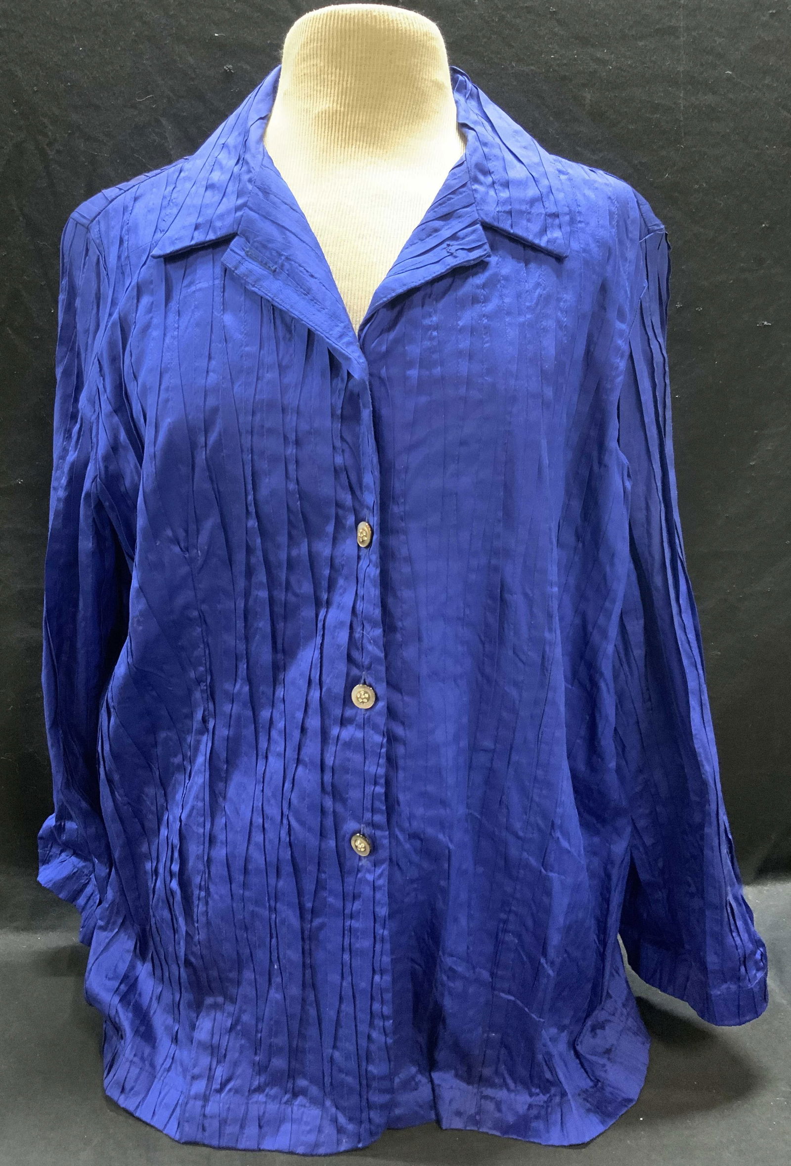 Mariko Blue Pleated Button Up Top: Mariko blue pleated button up top. Measures approx. 20 inches across chest. Material feels like silk, possibly synthetic. Fabric has some blemishes. Ladies top, ladies blue top, ladies button up top,