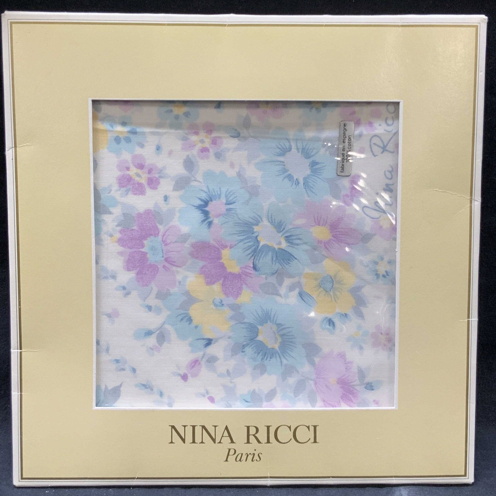 Nina Ricci Cotton Scarf NIP, Paris: Nina Ricci new in packaging cotton scarf with pink and blue pastel flowers. Never used. Approx 15 x 15 inches, moderate wearing to paper packaging. Nina Ricci cotton scarf, cotton scarf, Nina Ricci sc