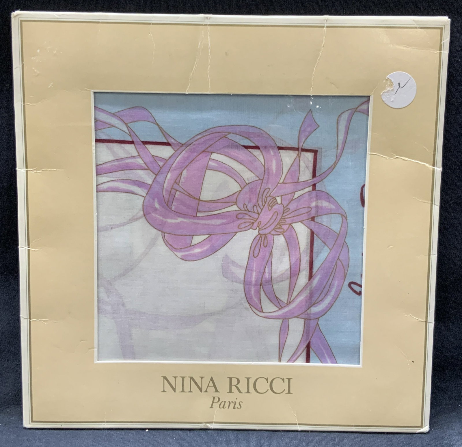 Nina Ricci Cotton Scarf NIP, Spain: Nina Ricci new in packaging cotton scarf with pink and blue pastel with ribbon motifs on corners. Never used. Approx 15 x 15 inches, moderate wearing to paper packaging. Nina Ricci cotton scarf, cotto