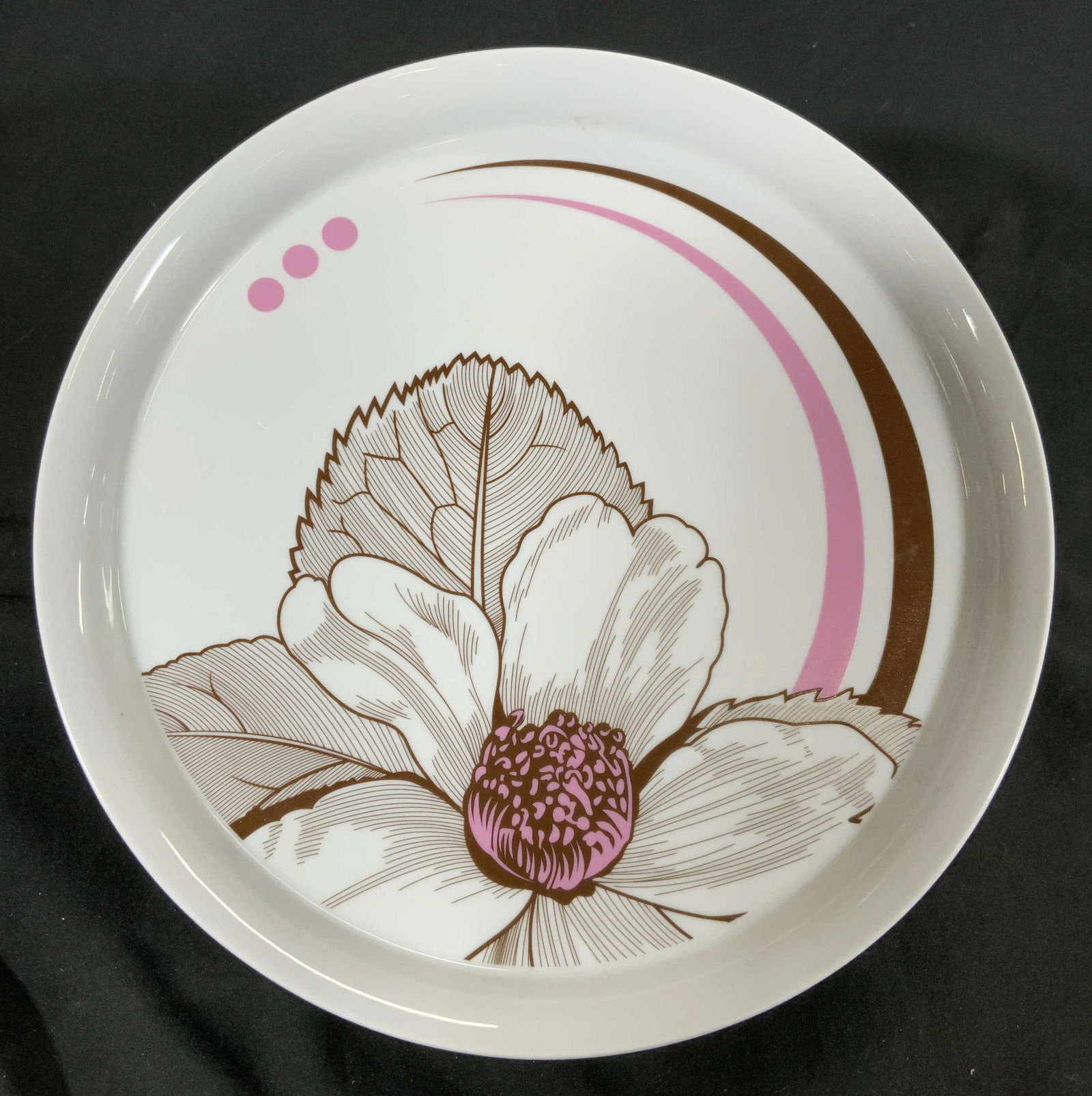 D STUDIO COCOA BLOOM Pedestaled Porc Cake Stand: Underside reads COCOA BLOOM BY D STUDIO. Cake stand is white with brown and pink toned floral and leaf detail. Cake stand is pedestaled. Piece is porcelain. Measures approximately 12 inches diameter 3
