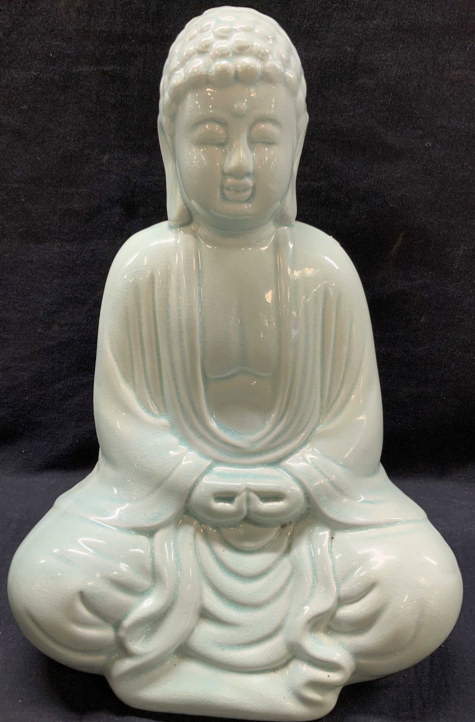 Glazed Ceramic Meditating Buddha Figure: Ceramic figure of a meditating Buddha in a light teal tone. Approx 14 inches tall and 9 inches wide. Crazing to glazing, possibly intentional and minor wearing near base. Buddha decor, ceramic decor, 