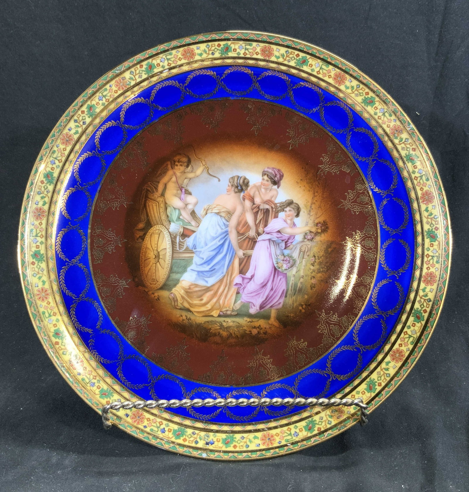 ROYAL VIENNA JK DECOR Porc Plate Partial Fem Nudes: Underside marked JK DECOR CARLSBAD & has Royal Vienna beehive trademark. Plate is porcelain. Piece has depiction of partial female nude figures & cherub in chariot. Edge is blue and yellow toned with 