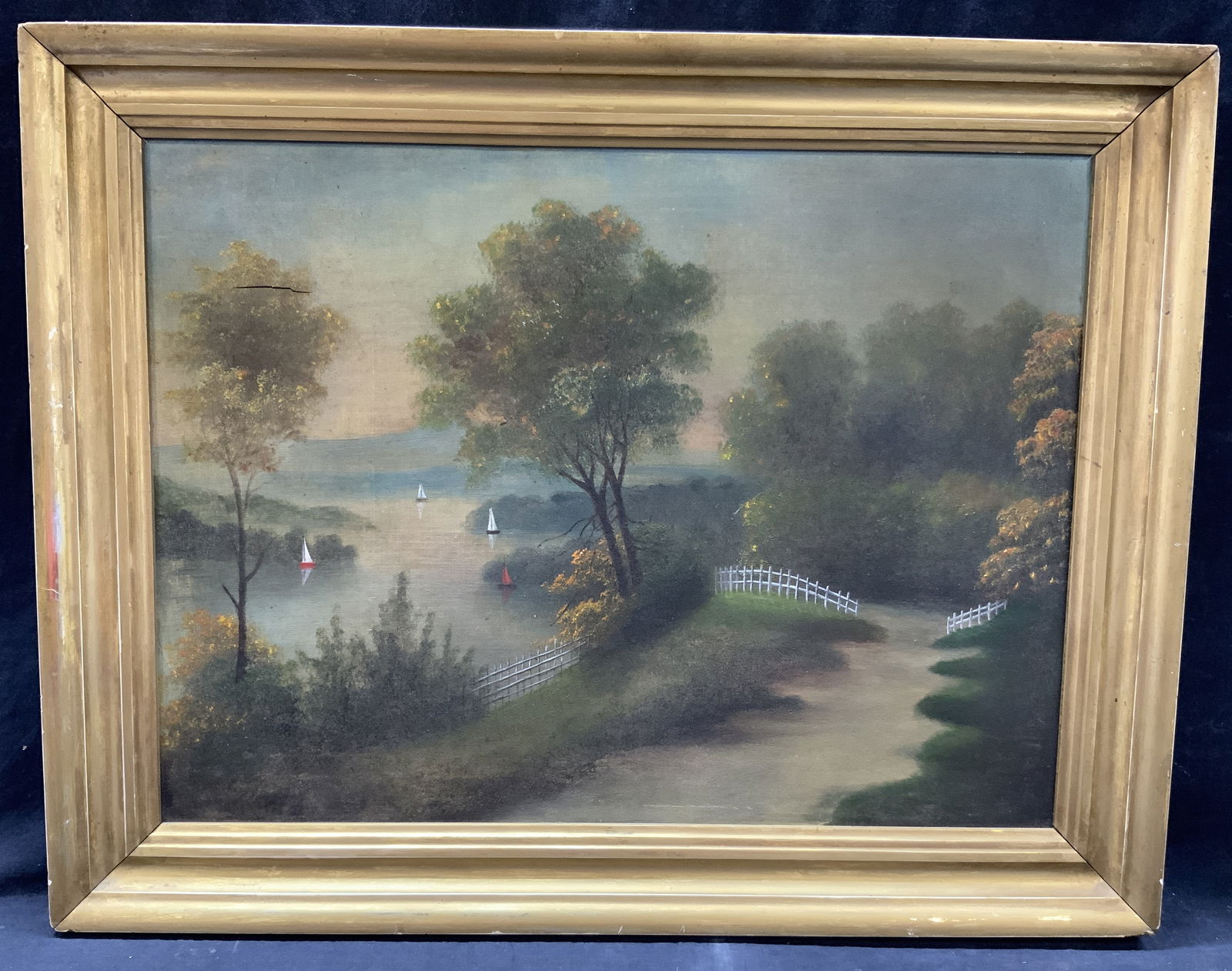 Vintage Landscape Oil Painting 28in: Vintage oil painting depicting a walking path near a forest with a lake on the side with various sail boats on the water. Framed in a gold leafed wooden frame, approx 22 x 28 inches window measures 17