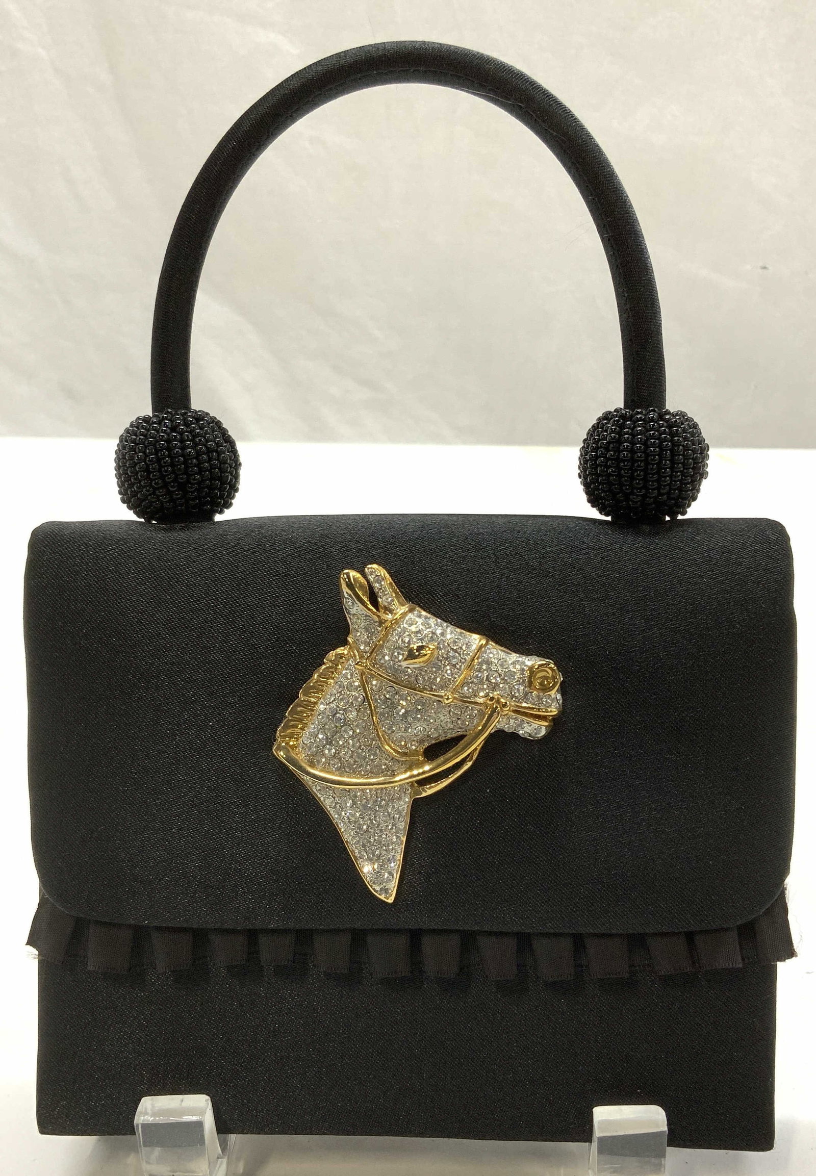 Marg of Pepper Pike Crystal Horse Motif Bag: Marg of Pepper Pike Black satin style minaudiere bag/ crossbody bag. Fold over flap has an ornamental crystal and gold tone horse , 2.25 x 2 in. Bag measures 5.5 x 4.5 in. Label is affixed to the inte