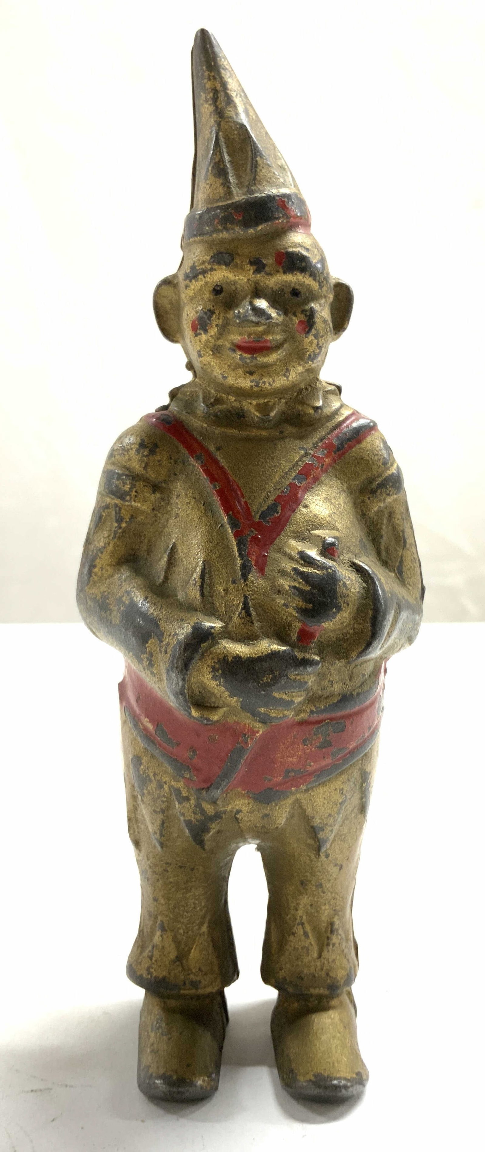 AC WILLIAMS Antique Gilt Iron Clown Coin Bank: Coin bank appears to be AC WILLIAMS (no apparent markings). Piece is iron with gilt and red toned finish. Depicts a standing clown figure wearing a hat. Coin slot on backside. Piece measures approxima