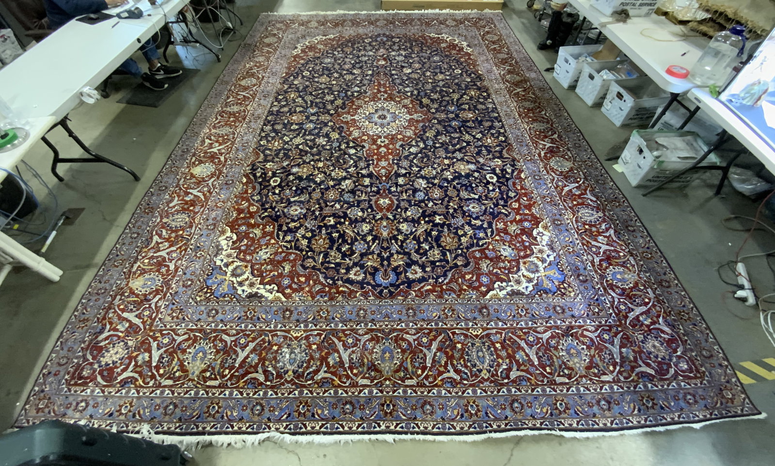 Vintage Room Sized Handmade Persian Rug: A vintage handmade Persian rug featuring fringe trim. Primarily red, blue, yellow, white, and pink hues. Floral, foliage, and geometric patterns throughout. Measures approx. 201L x 137.5W in. Appears 